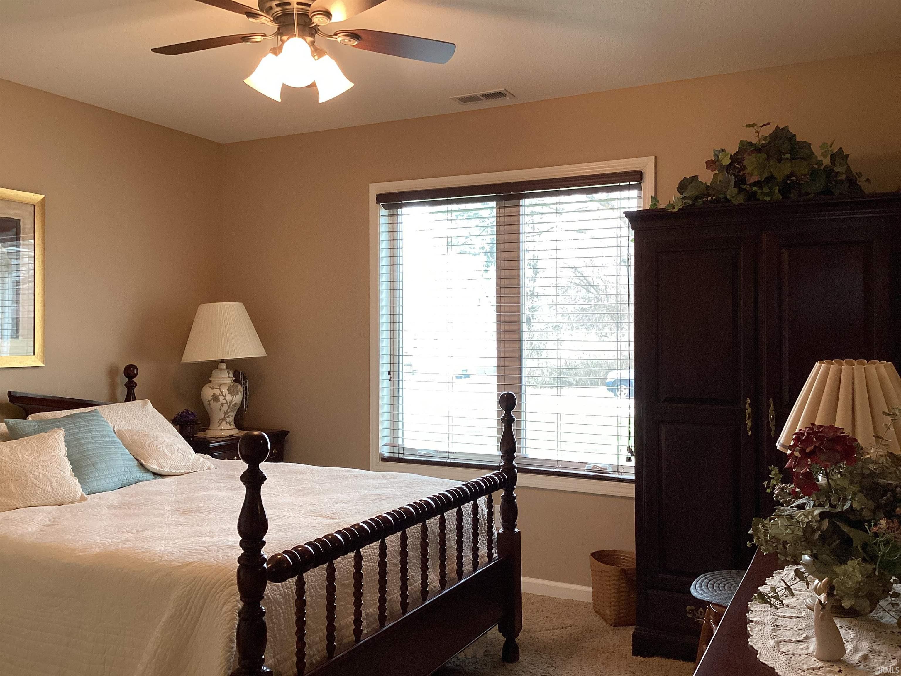 Carpeted bedroom featuring a ceiling fan and baseboards