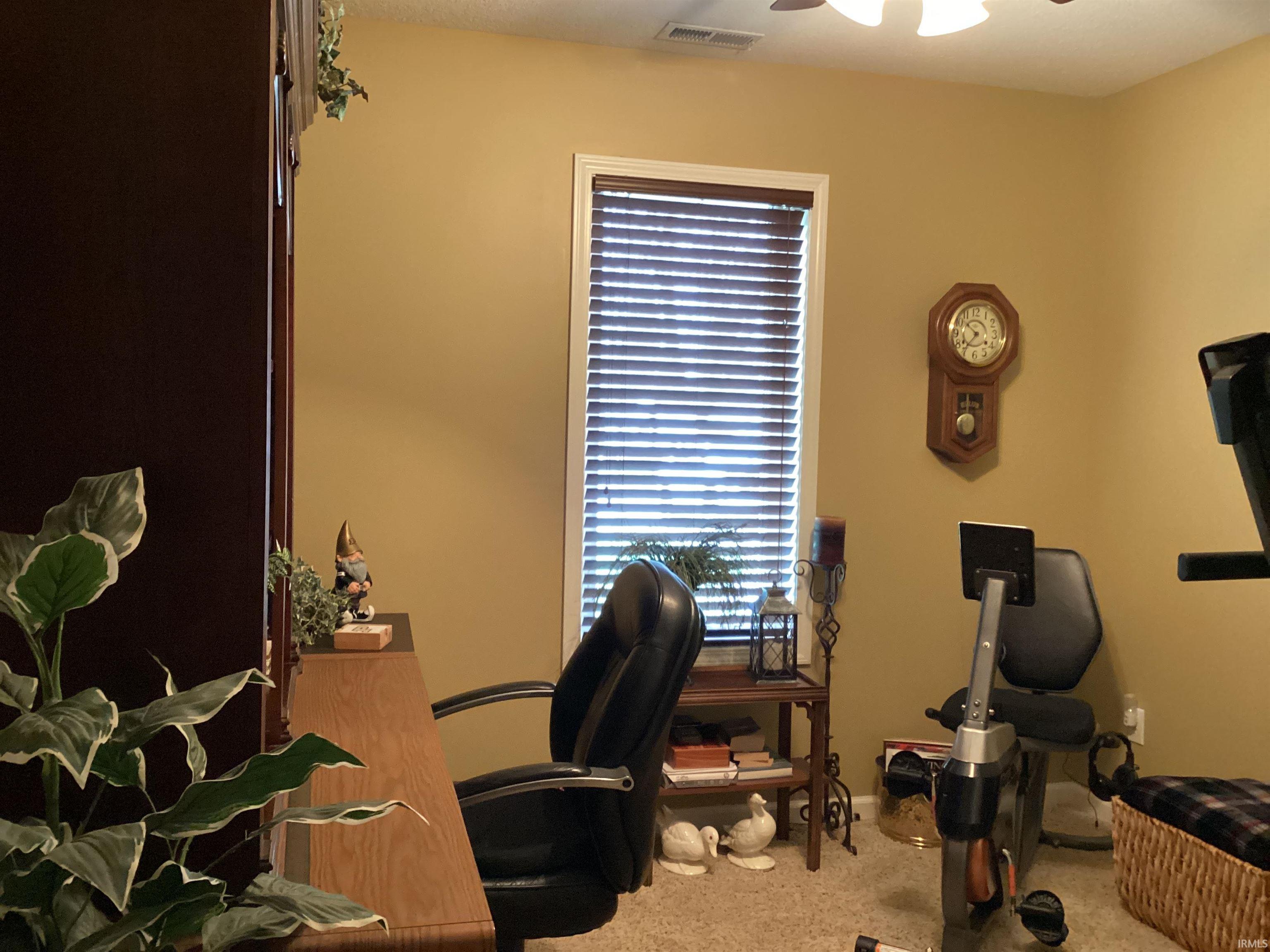 Home office featuring light colored carpet and ceiling fan