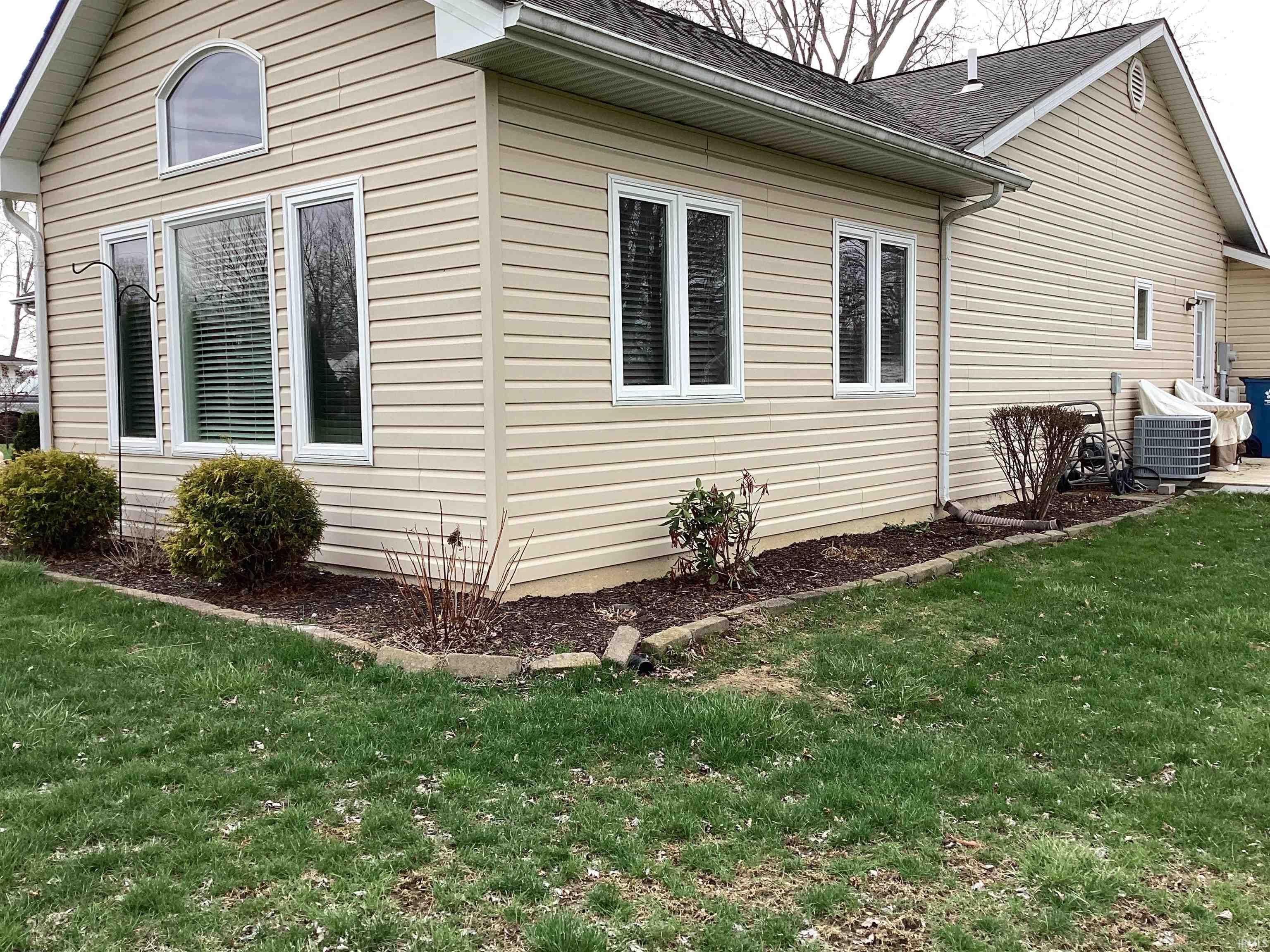 View of home's exterior featuring a shingled roof and a lawn