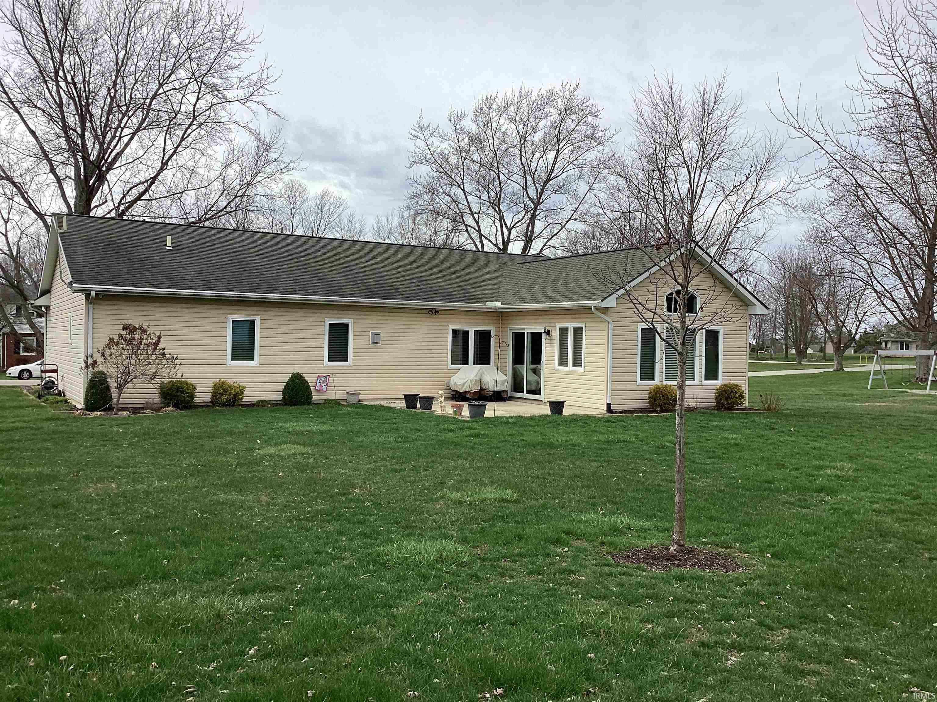 Back of property with a patio area, a yard, and a shingled roof