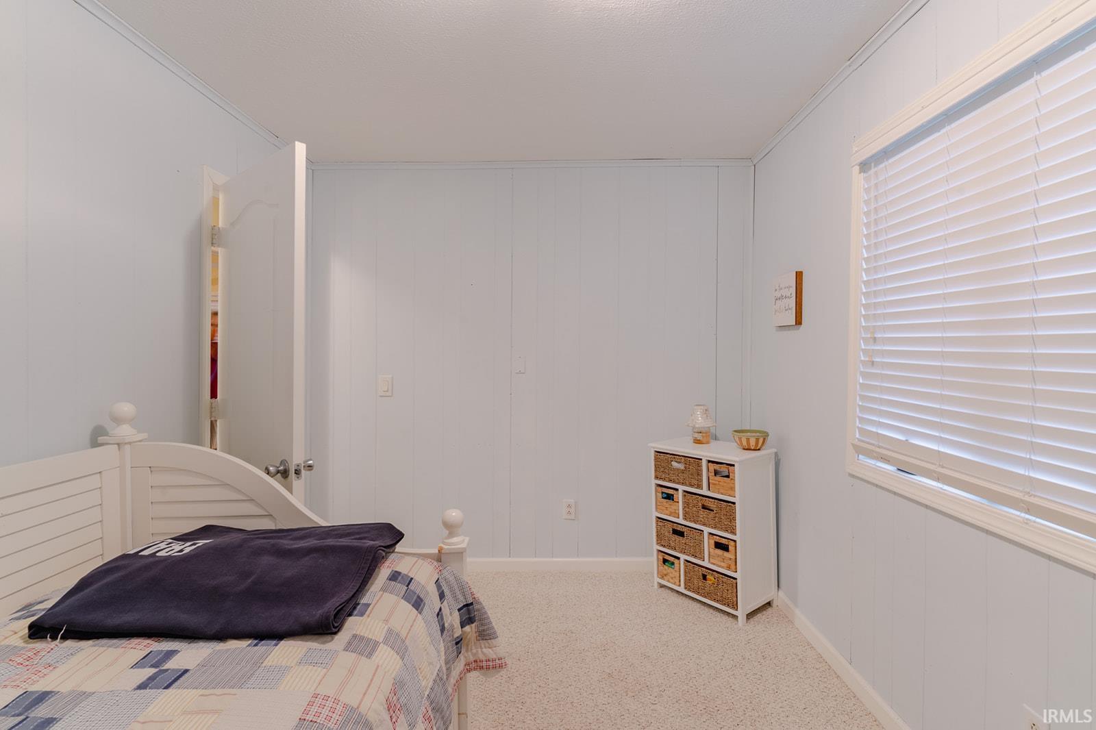 Bedroom featuring light colored carpet and crown molding