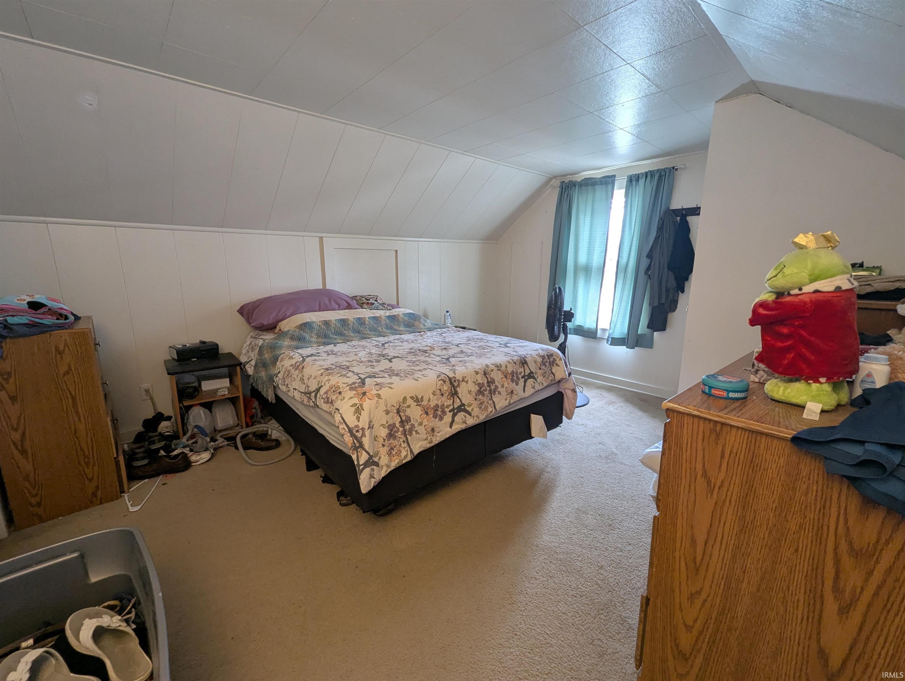 Bedroom featuring carpet and lofted ceiling