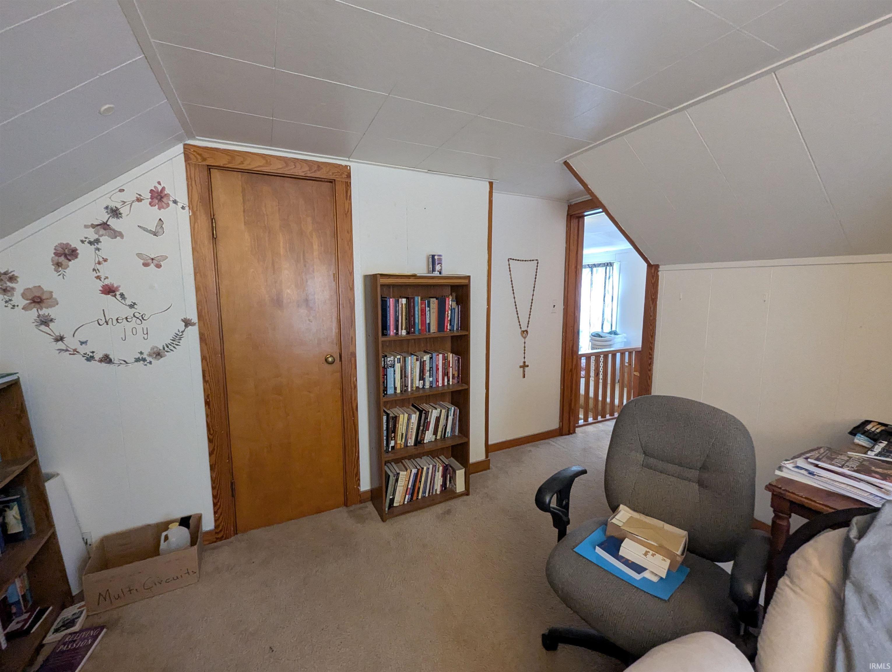 Sitting room featuring light colored carpet, lofted ceiling, and a desk