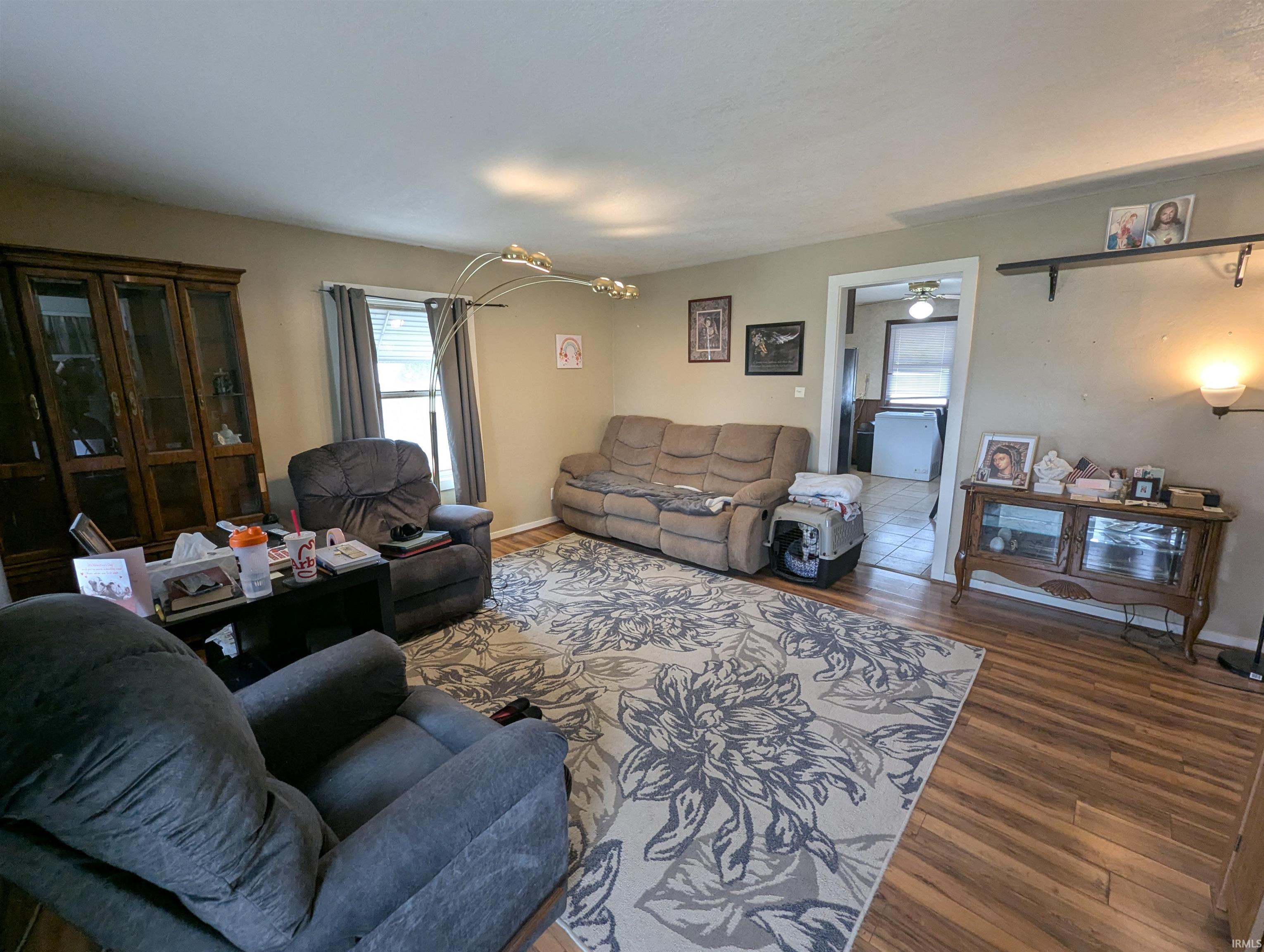 Living area with wood finished floors, healthy amount of natural light, and hanging lights