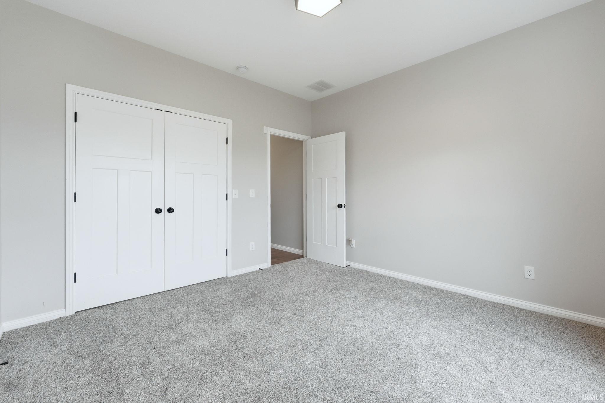 Unfurnished bedroom featuring carpet floors and a closet
