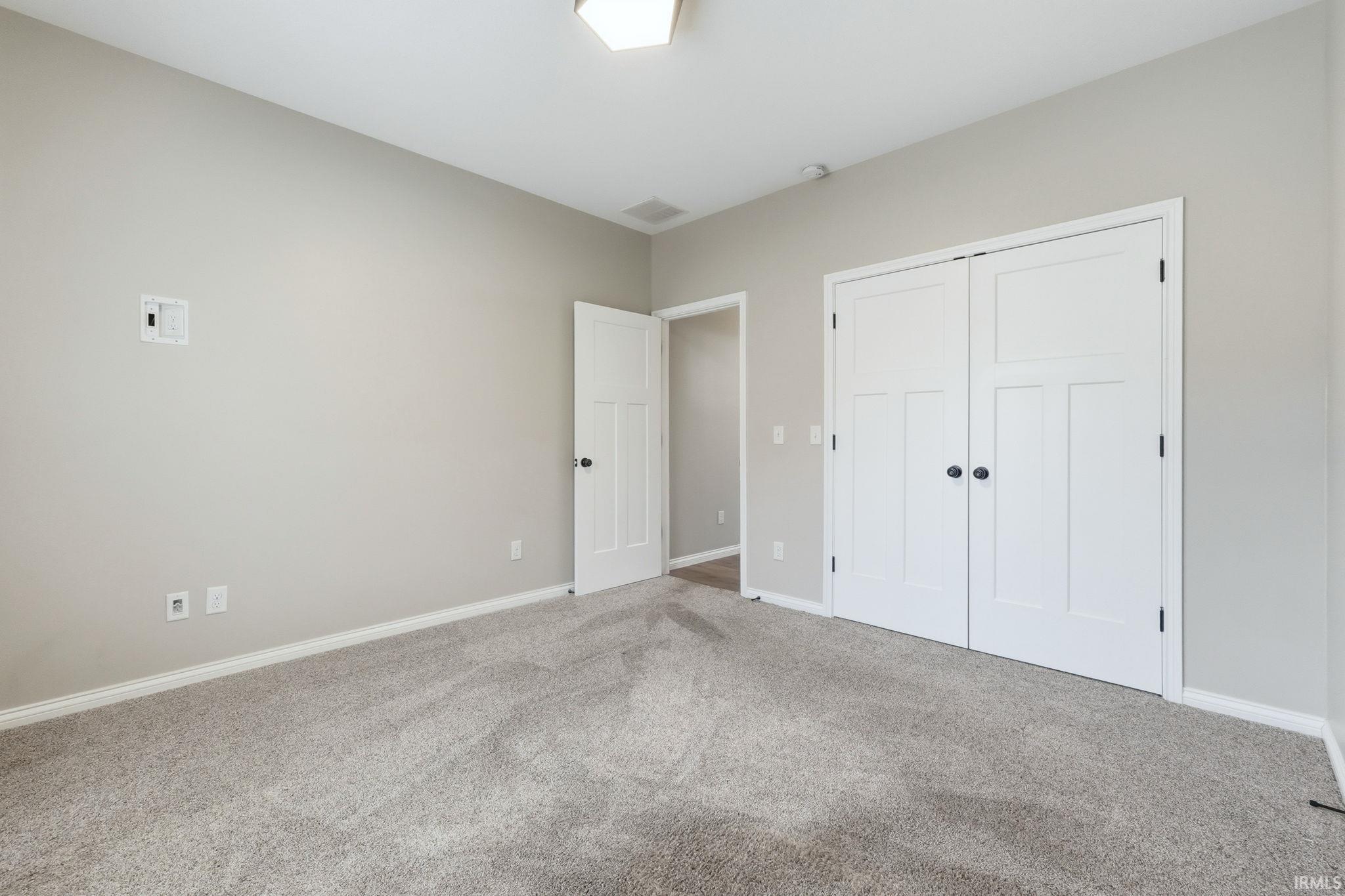 Unfurnished bedroom with carpet and a closet