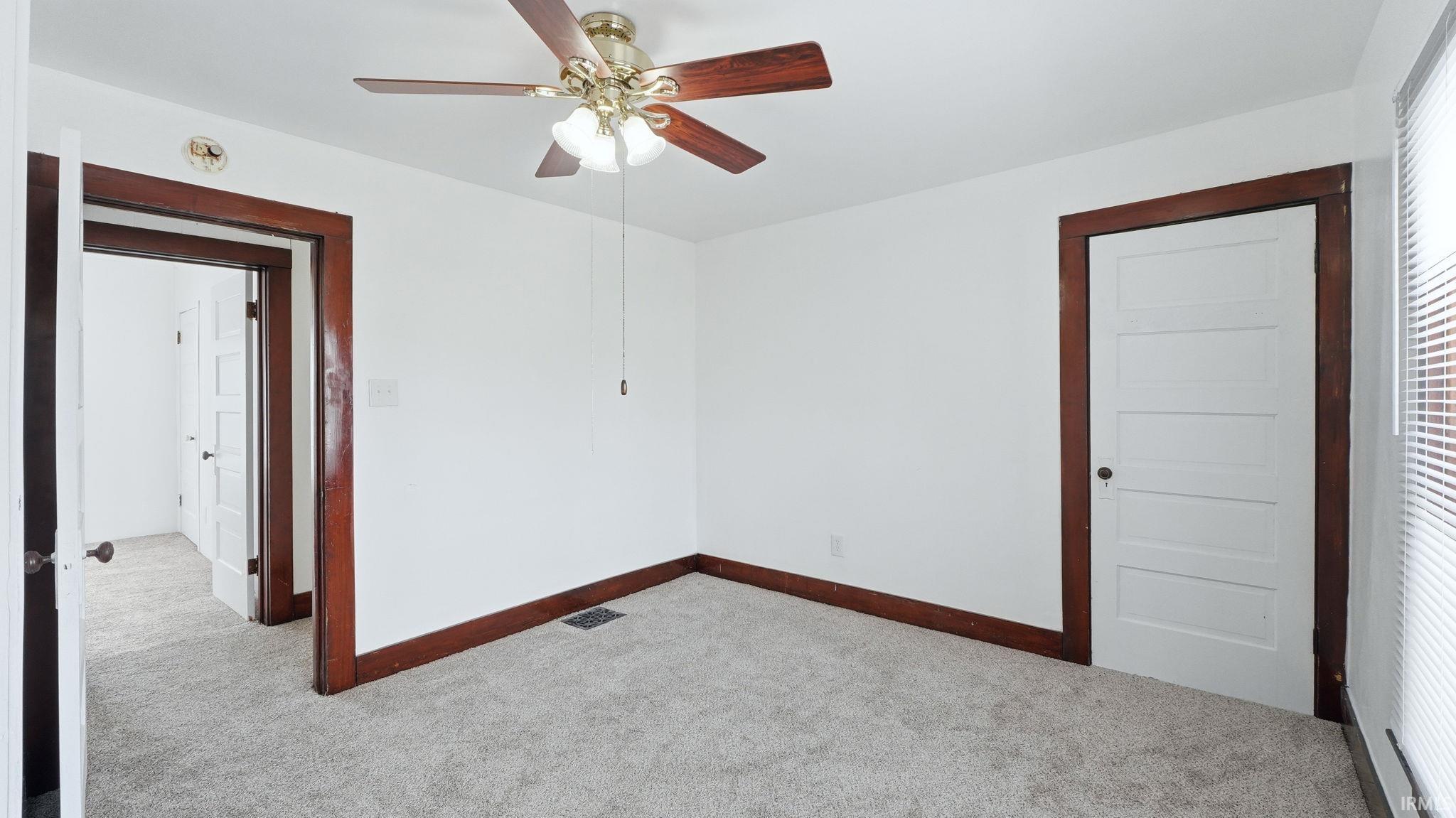 Spare room with light carpet and ceiling fan