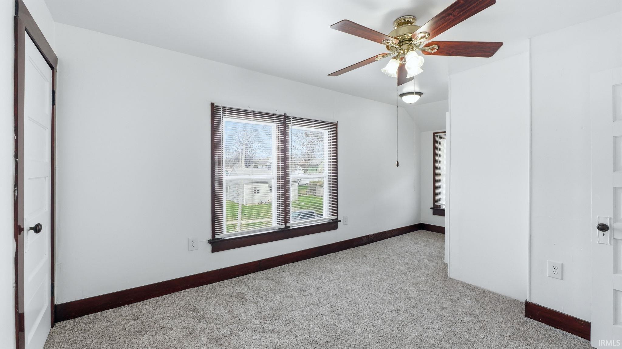 Unfurnished bedroom featuring light carpet and ceiling fan