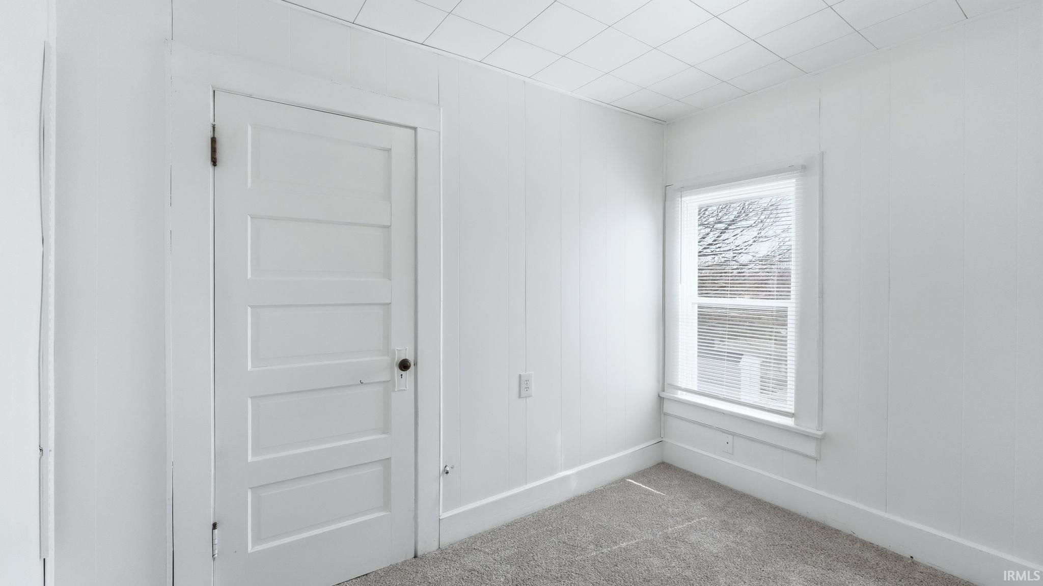 Spare room with carpet and baseboards