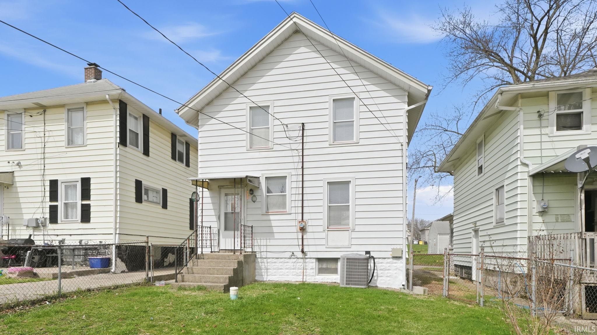 Rear view of house with a fenced backyard and a gate