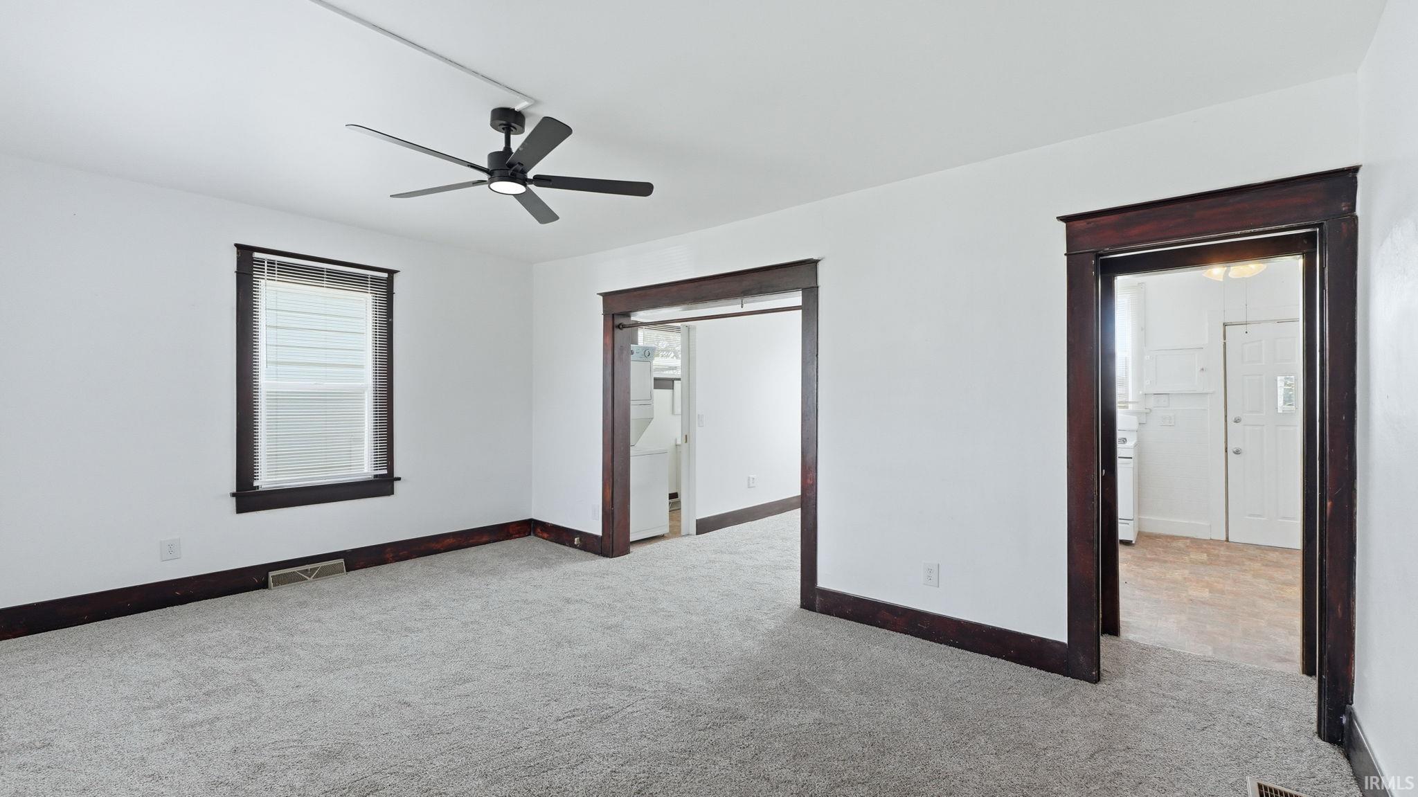 Unfurnished bedroom featuring light colored carpet and a ceiling fan