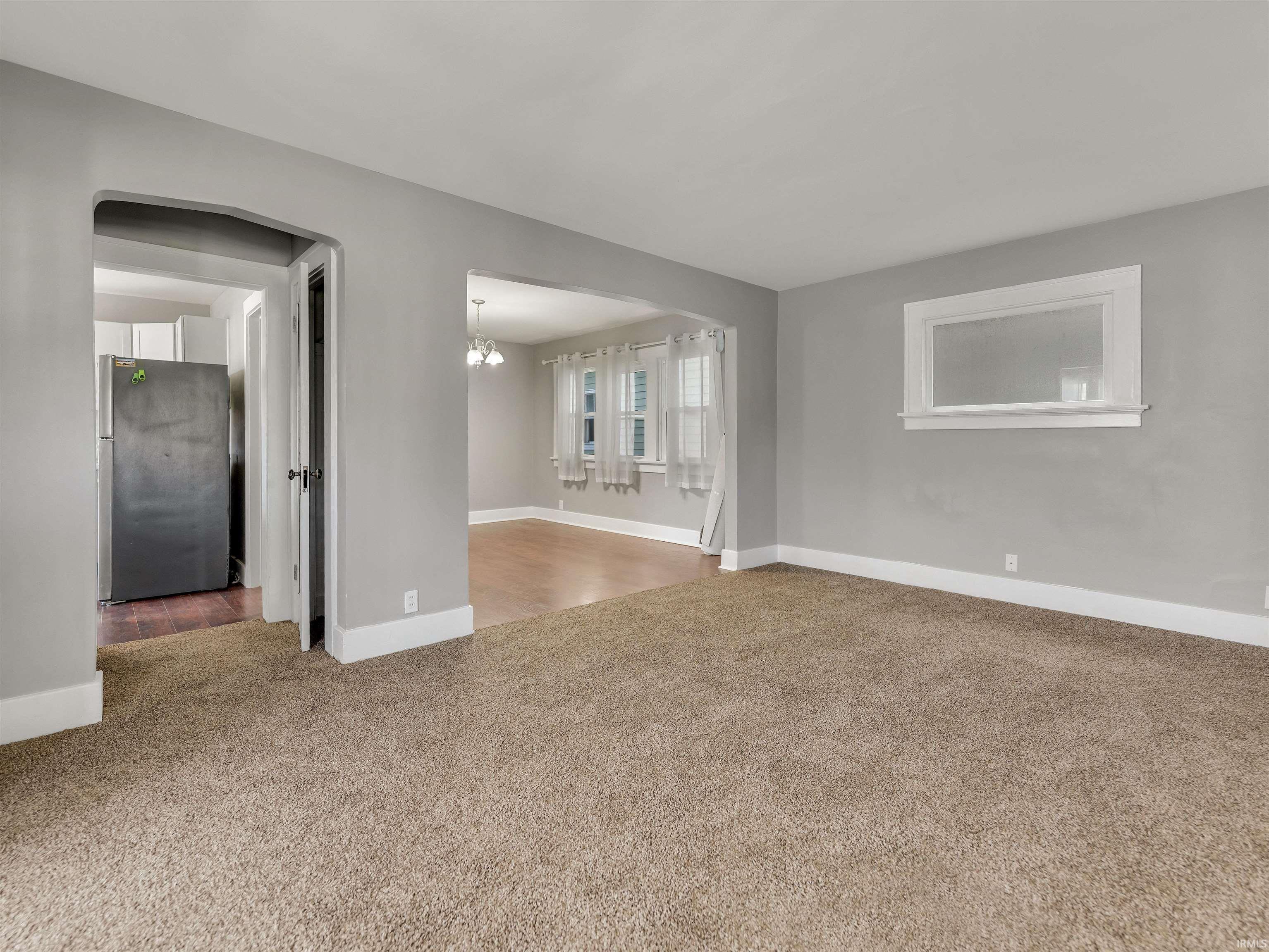 Carpeted living area with light gray walls and white trim