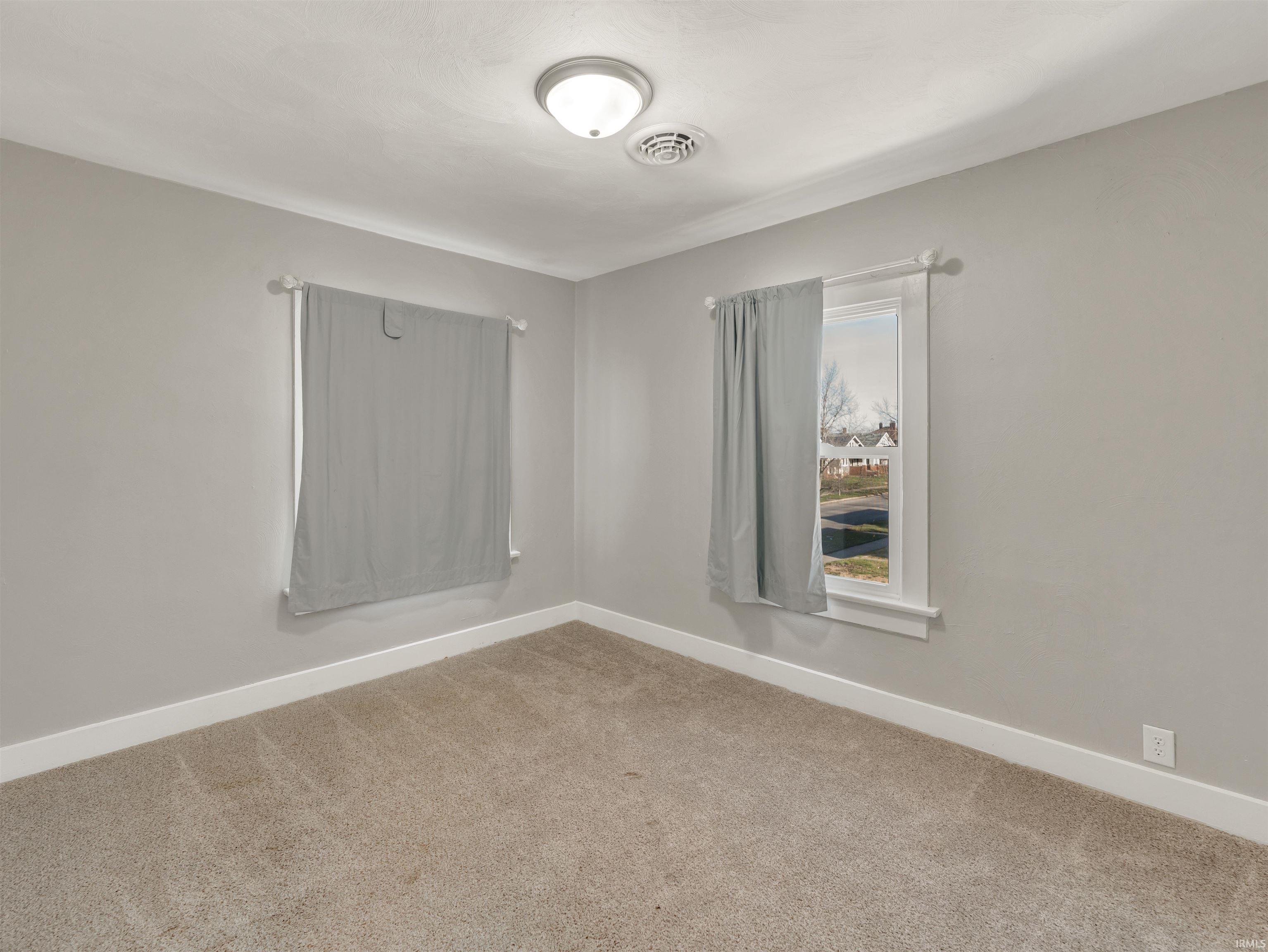 Empty room with baseboards and carpet