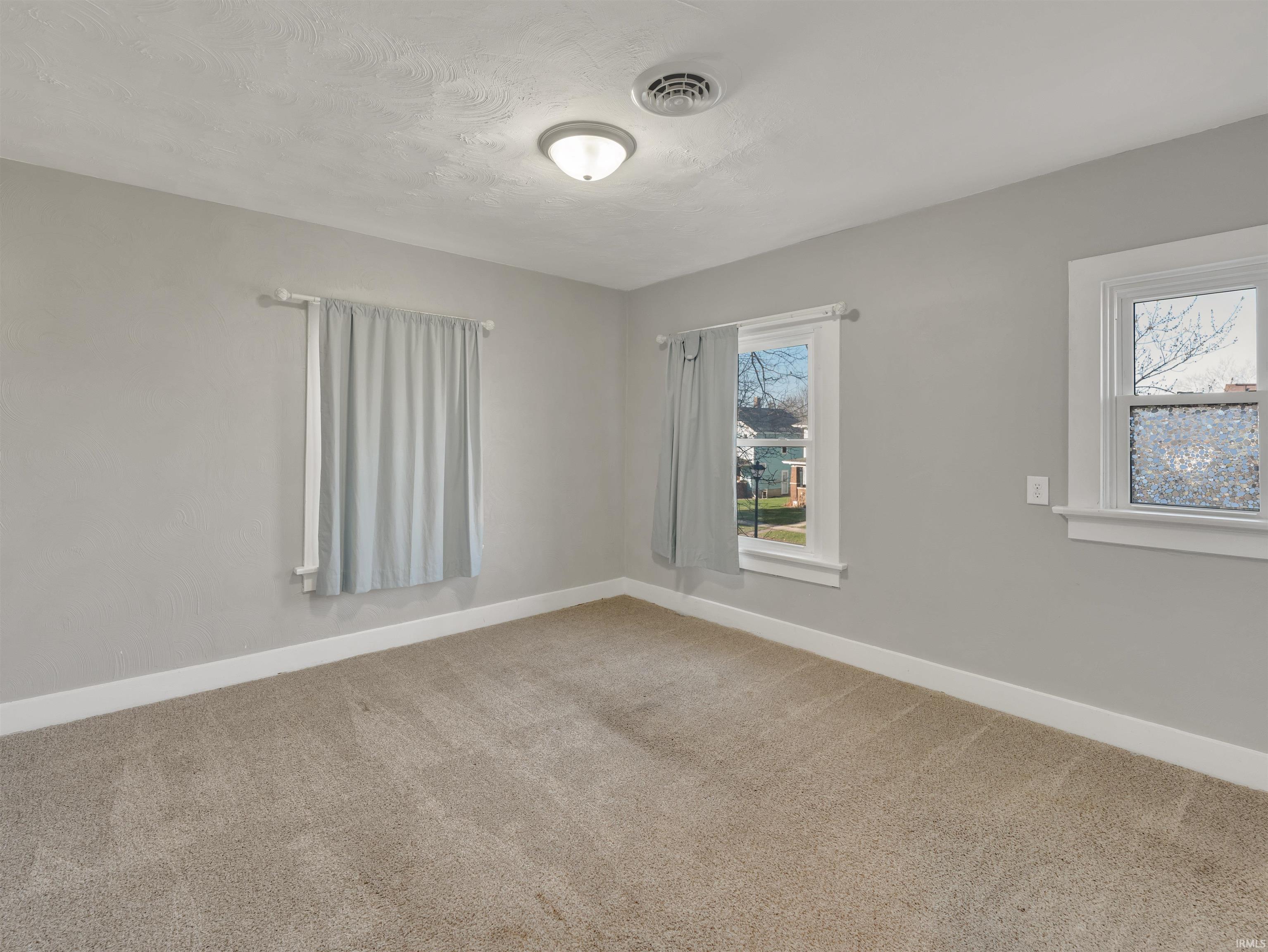 Carpeted empty room with baseboards