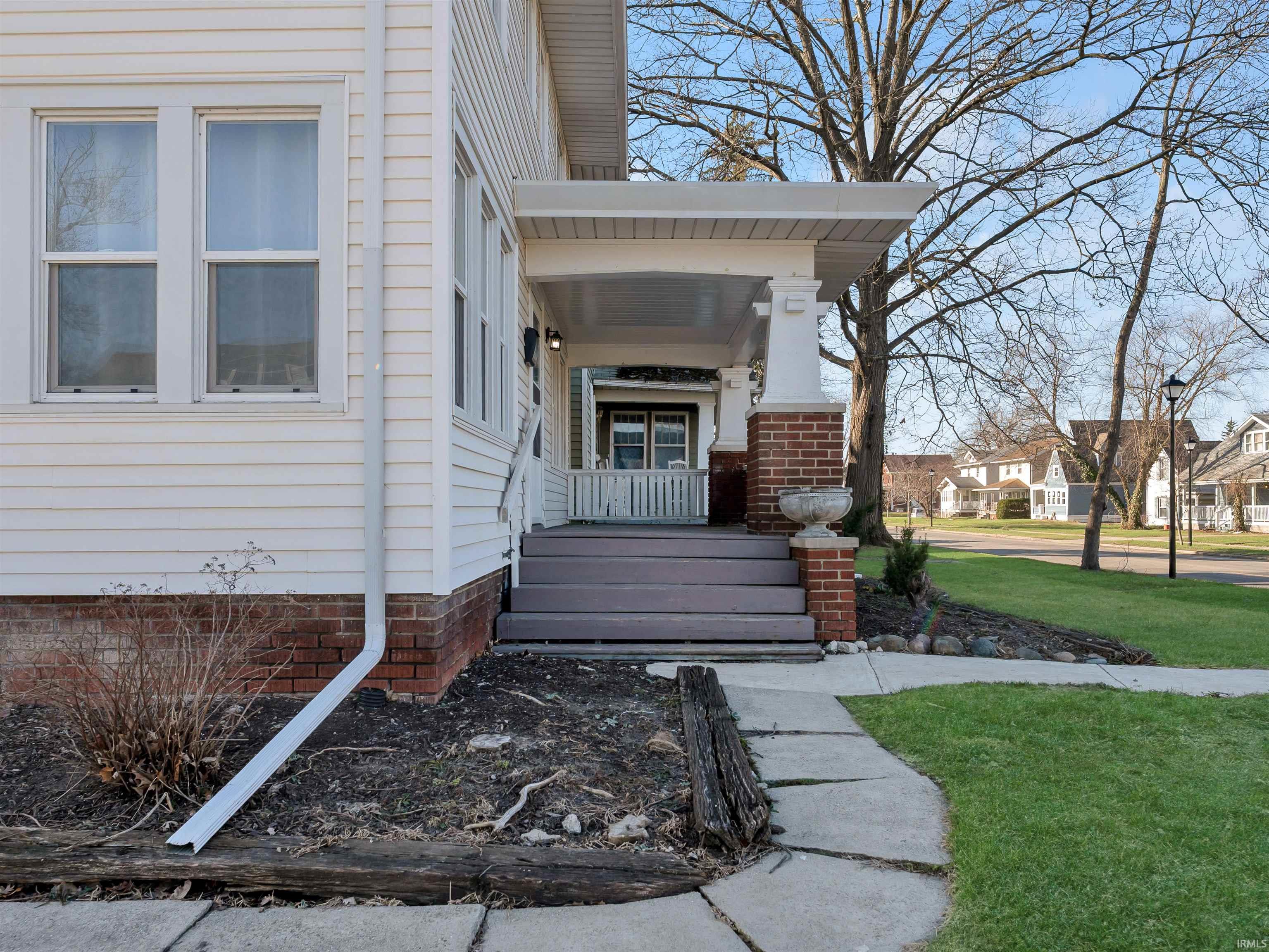 View of exterior entry with a porch, a lawn, and a residential view