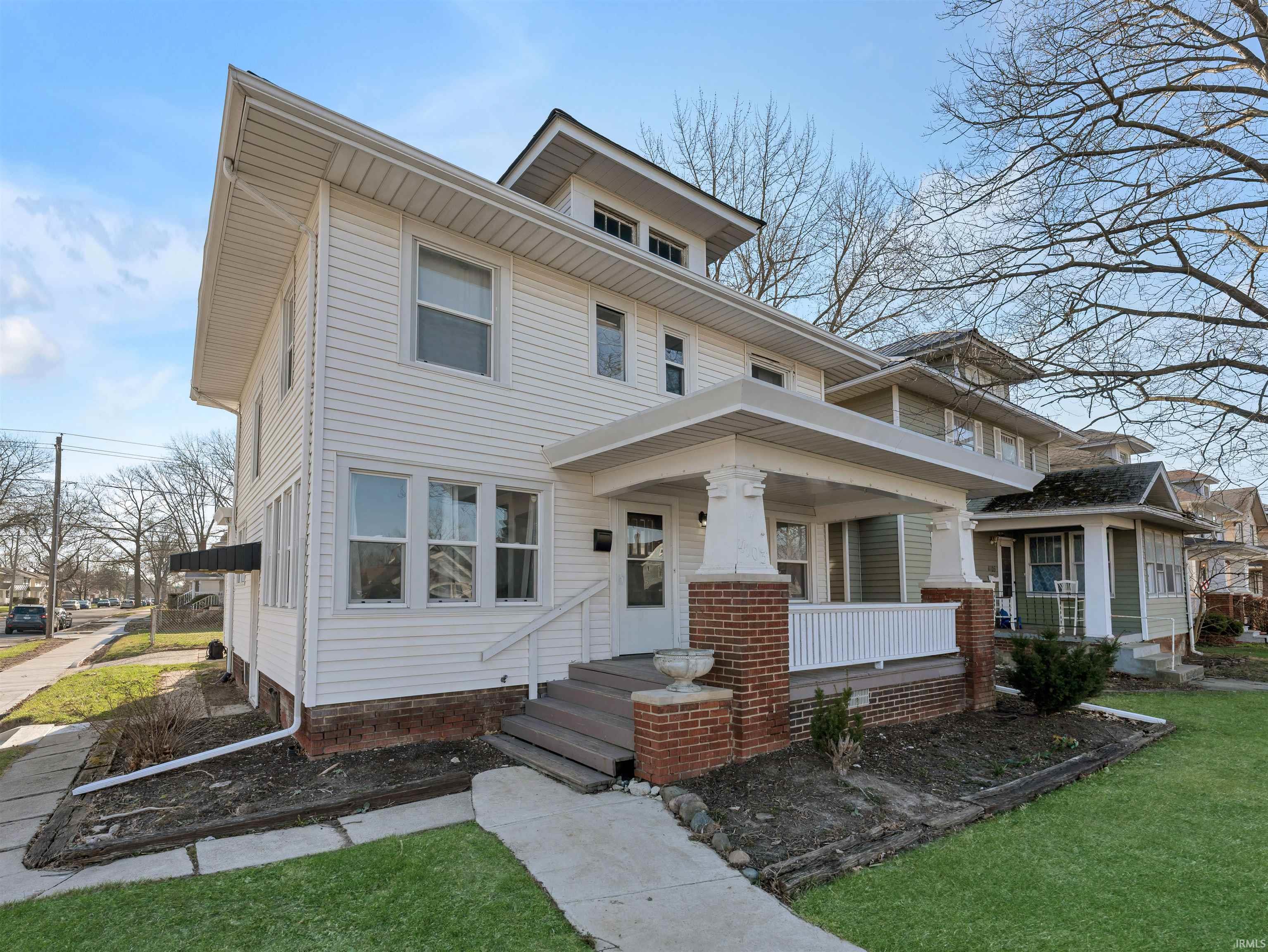 Traditional style home with a porch and a front yard
