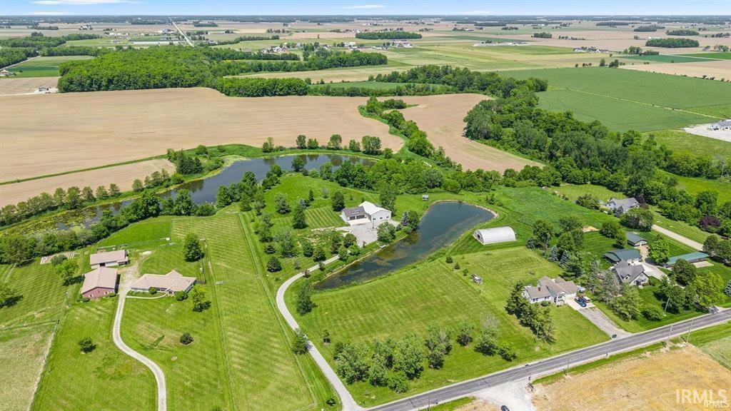 Overview of rural landscape featuring rows of crops and a nearby body of water