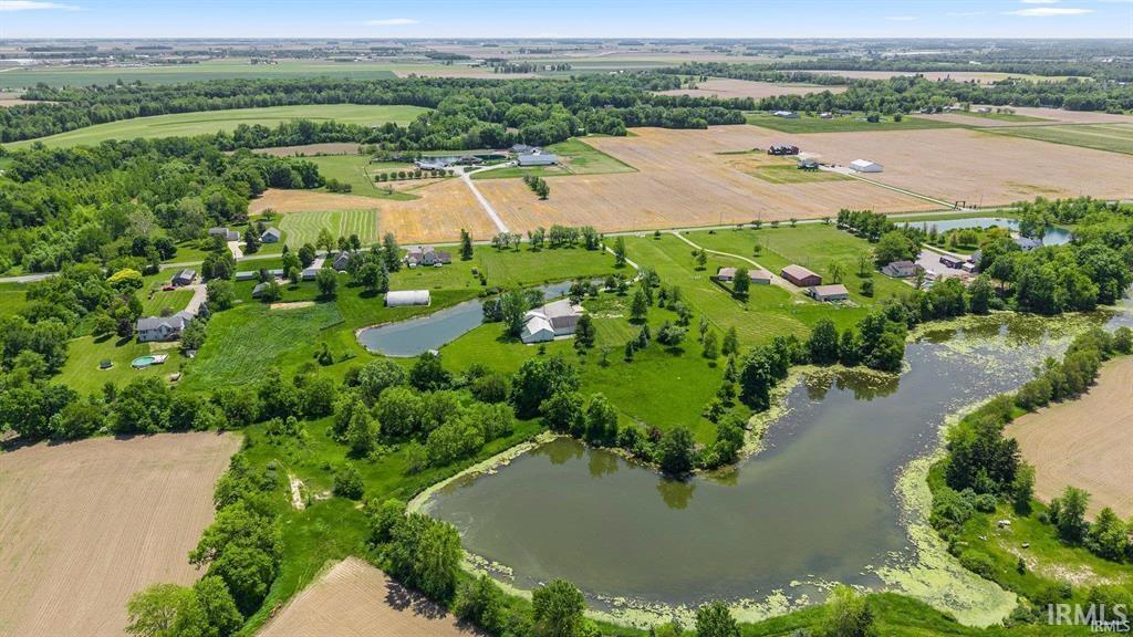 Aerial view of sparsely populated area with rows of crops and a large body of water