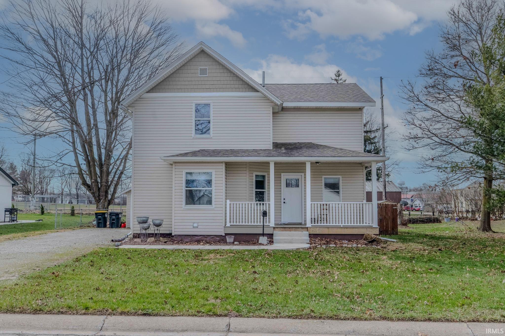 View of front of home with covered porch and a shingled roof