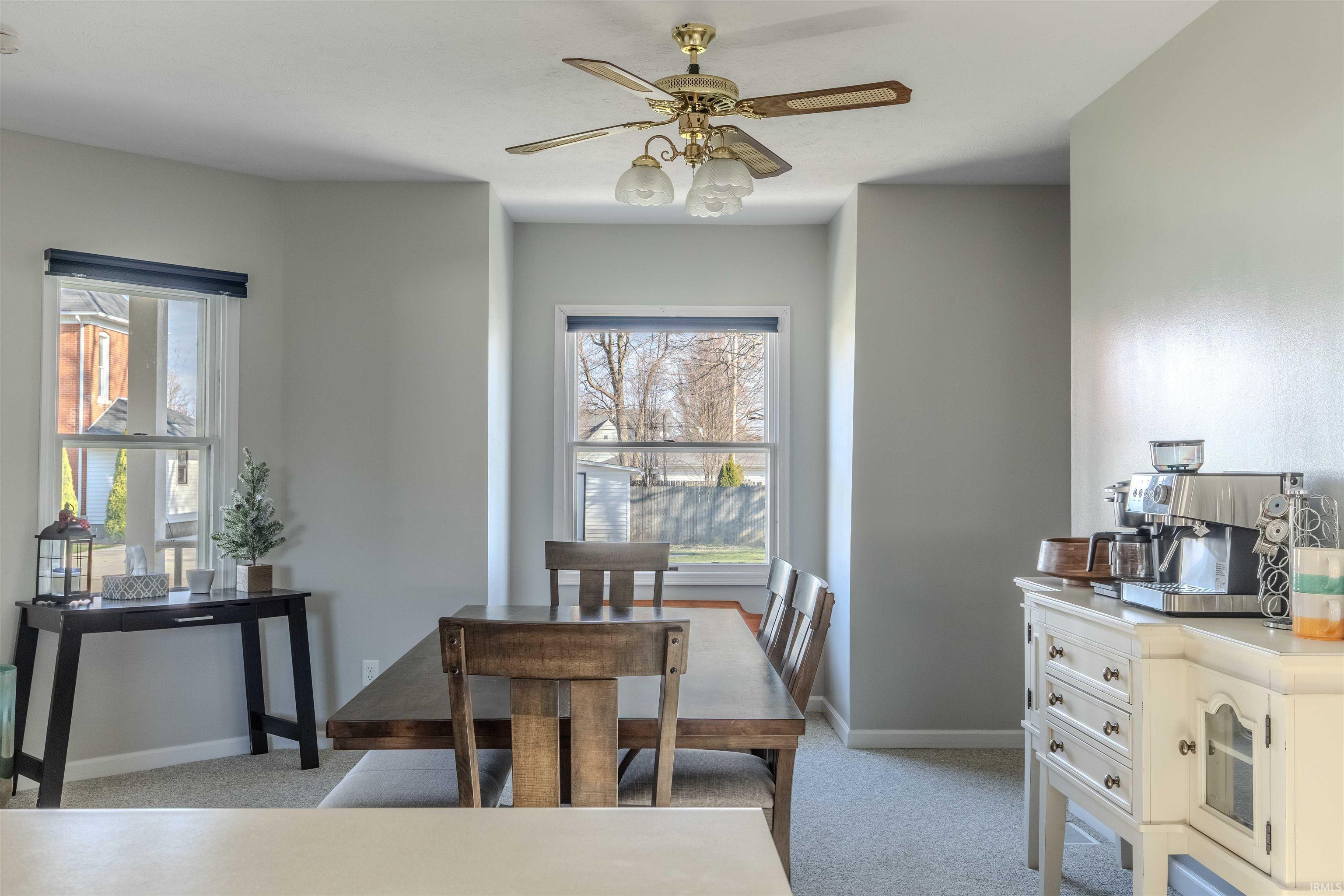 Dining space with light carpet and ceiling fan