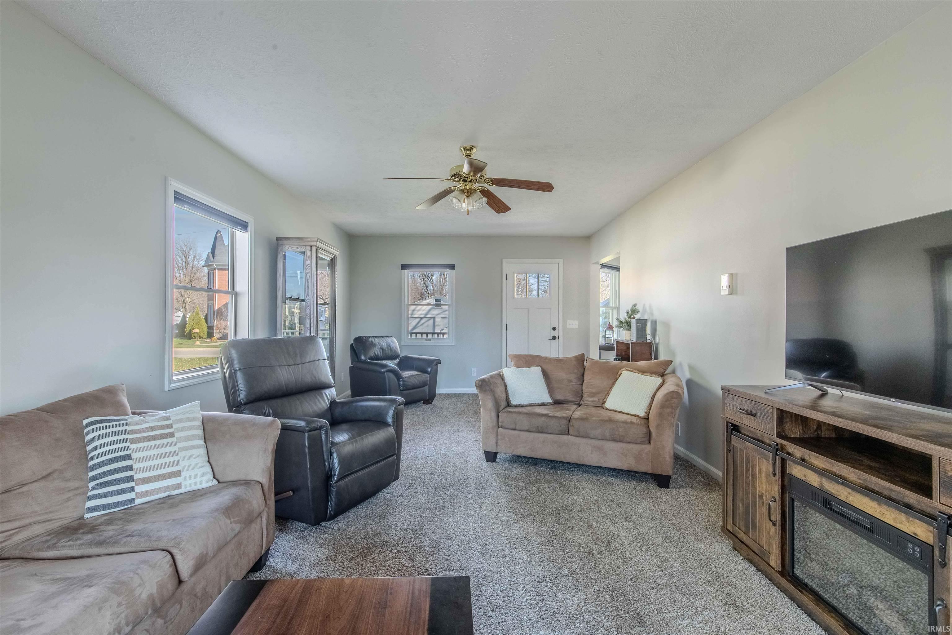 Living room featuring ceiling fan and carpet flooring