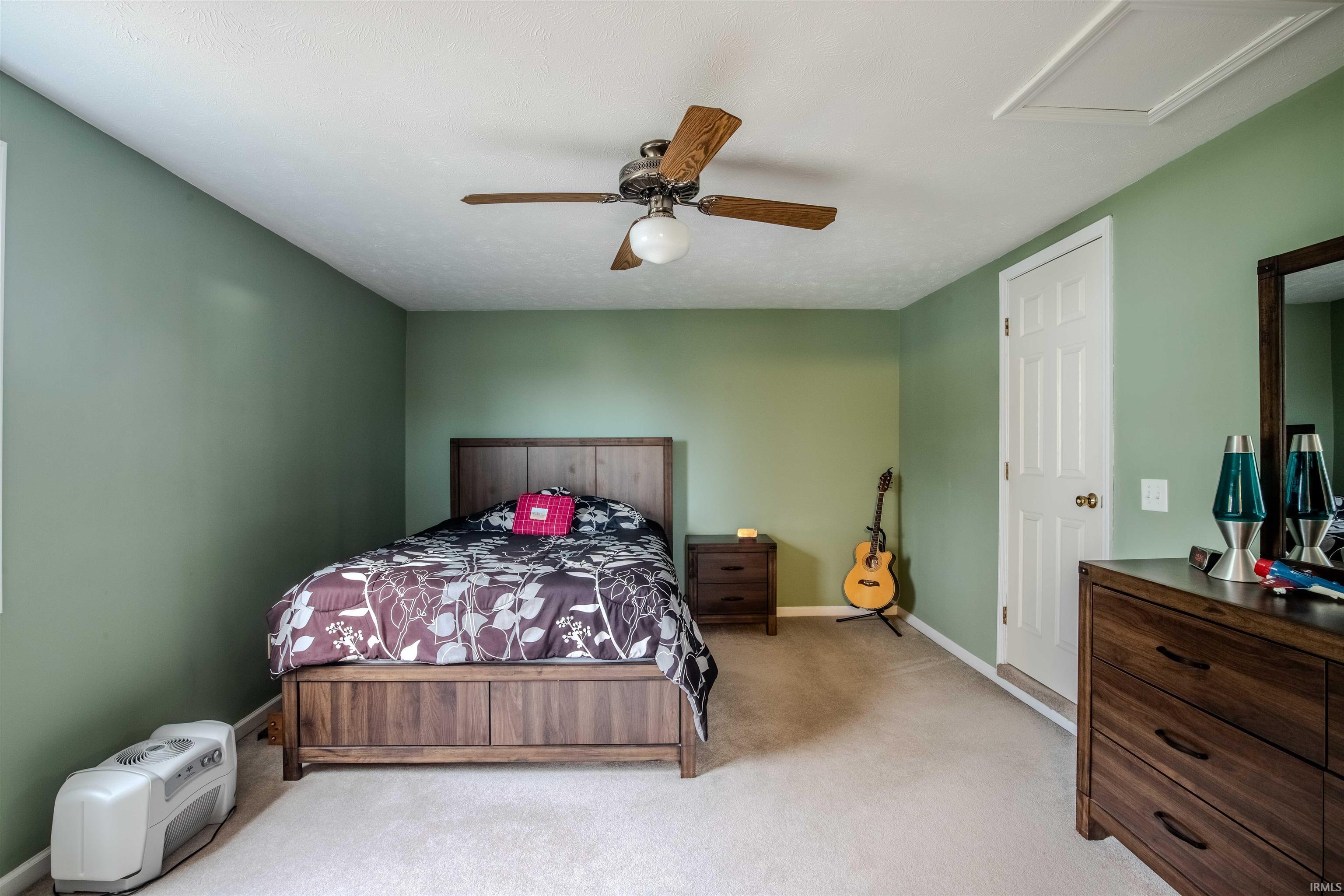 Bedroom with light carpet and a ceiling fan