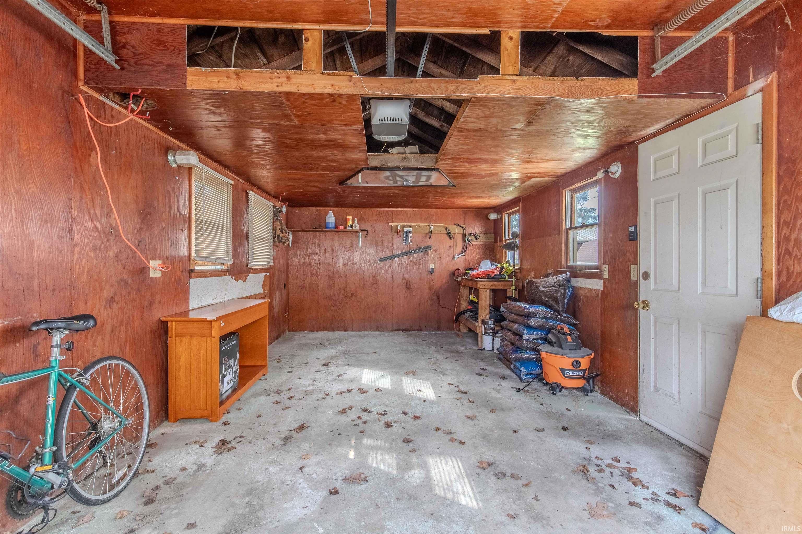 Garage with wooden walls and a garage door opener