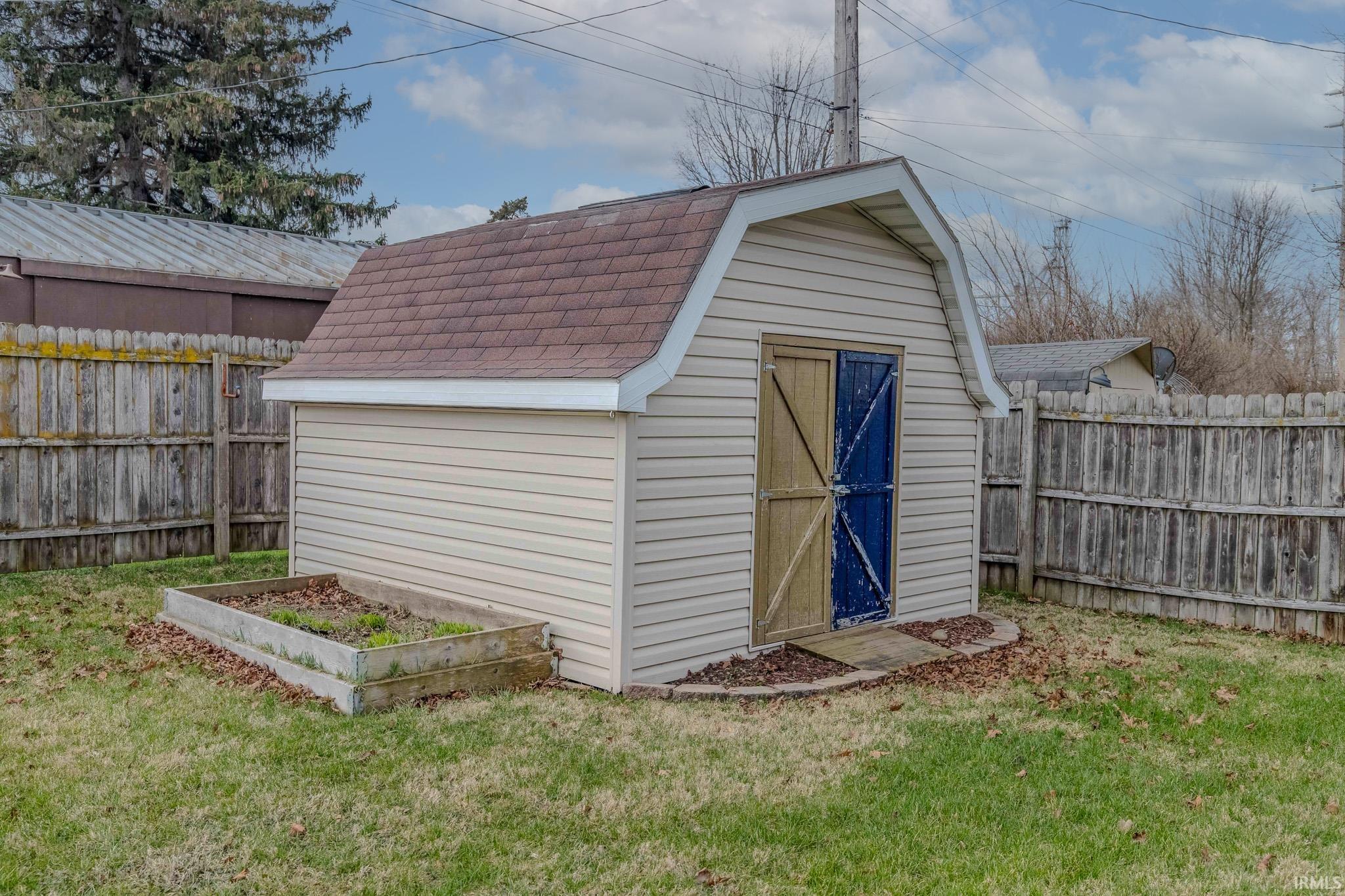 View of shed featuring a vegetable garden and a fenced backyard