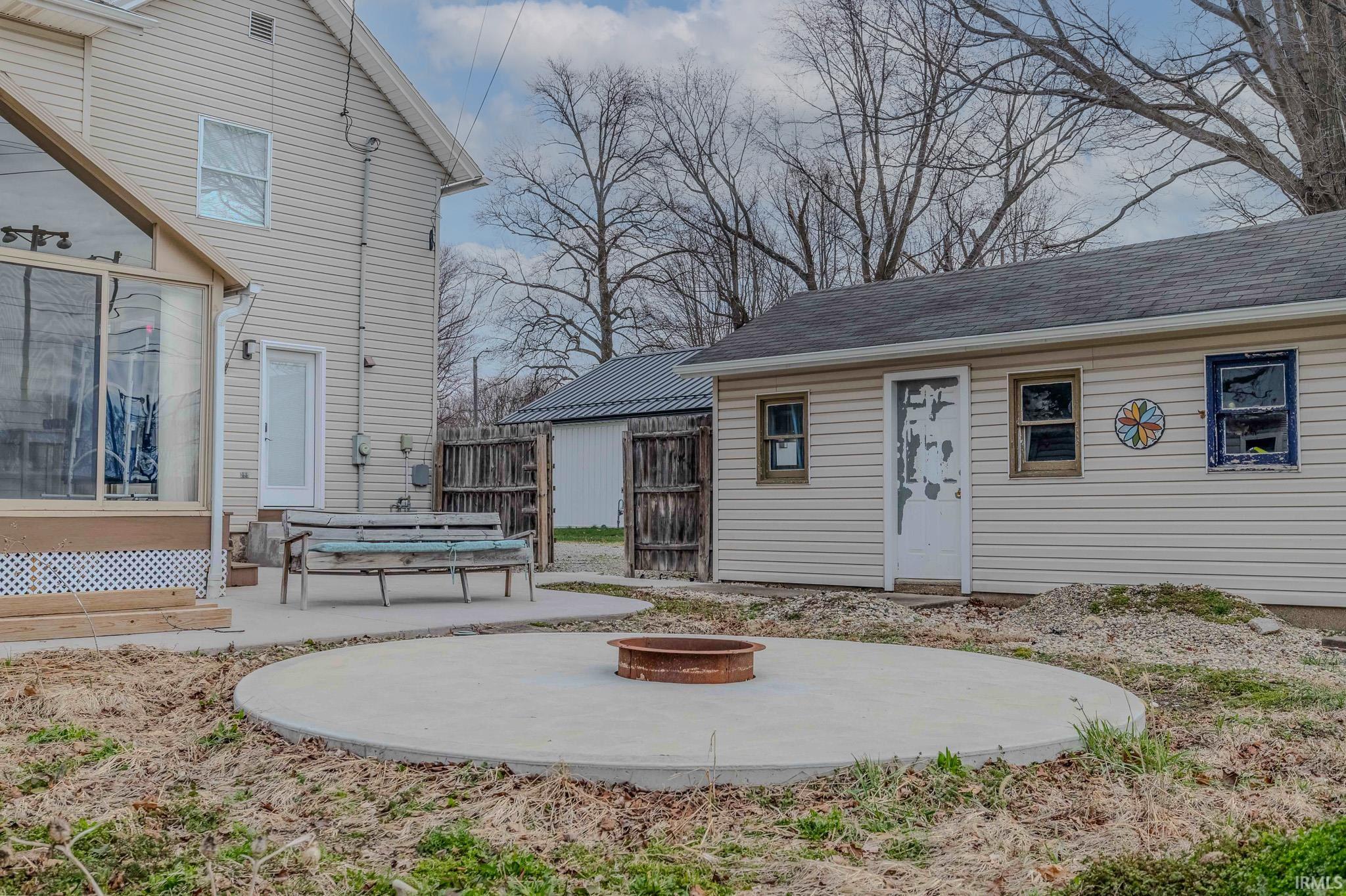 View of yard featuring a patio area, a fire pit, entry steps, and an outdoor structure