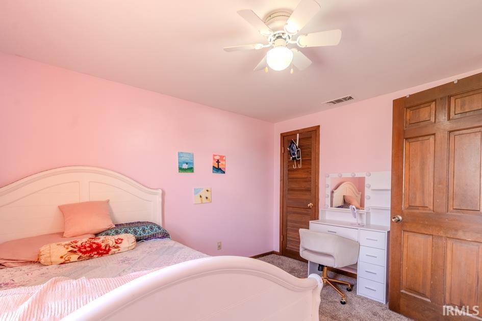 Bedroom with a closet, carpet, and a ceiling fan