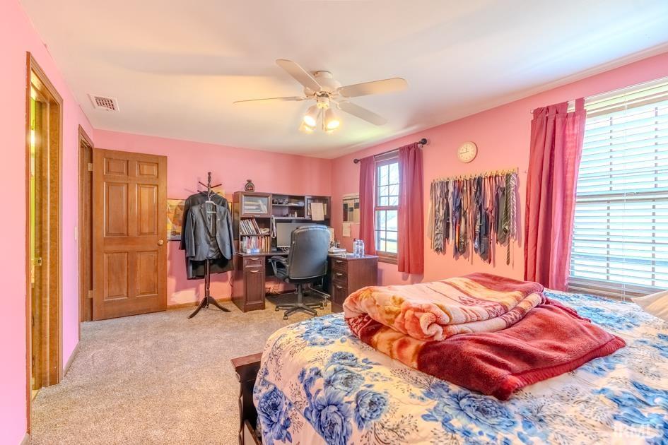 Bedroom with a desk, a ceiling fan, and carpet