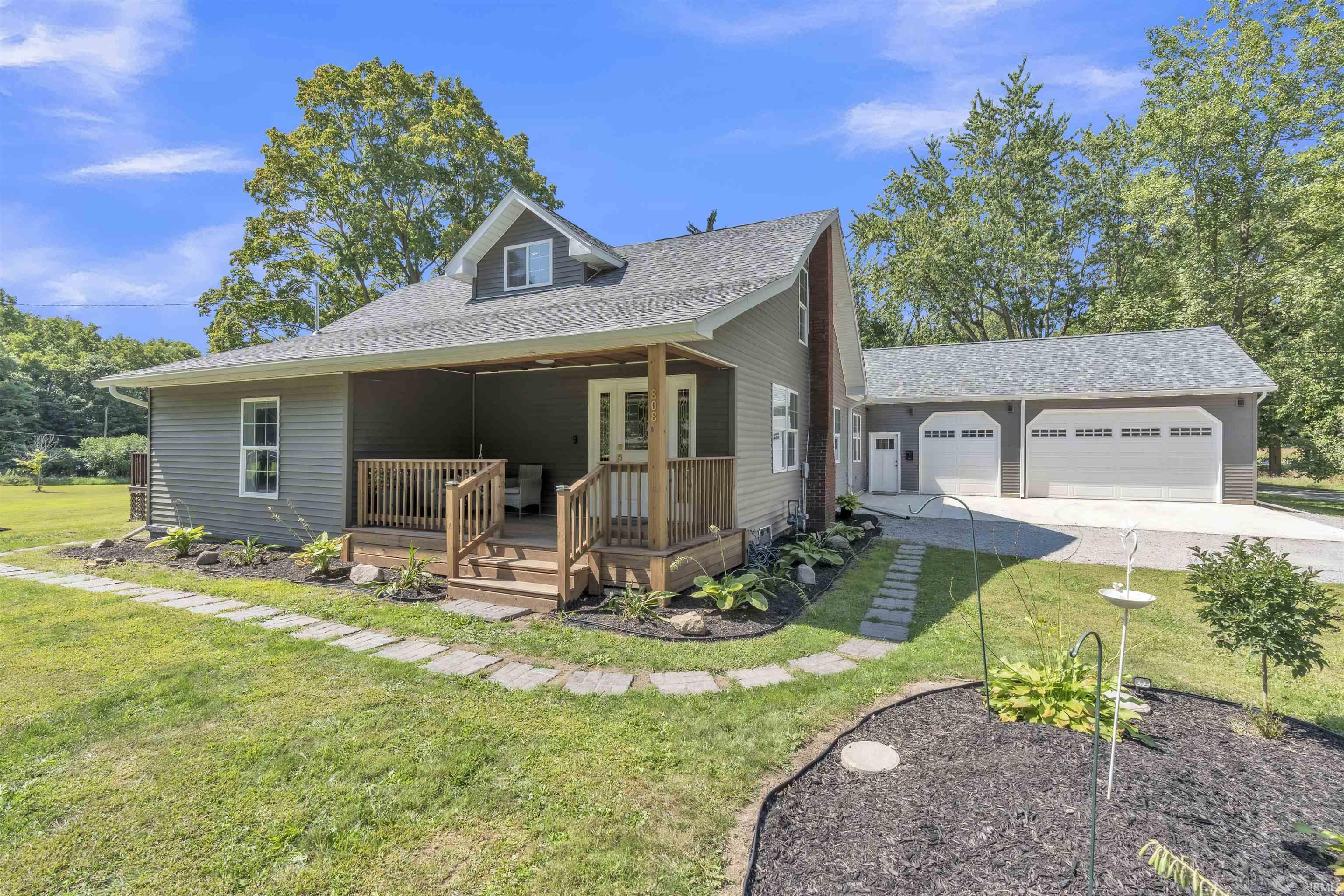 View of front of house featuring a front yard, roof with shingles, a garage, and concrete driveway