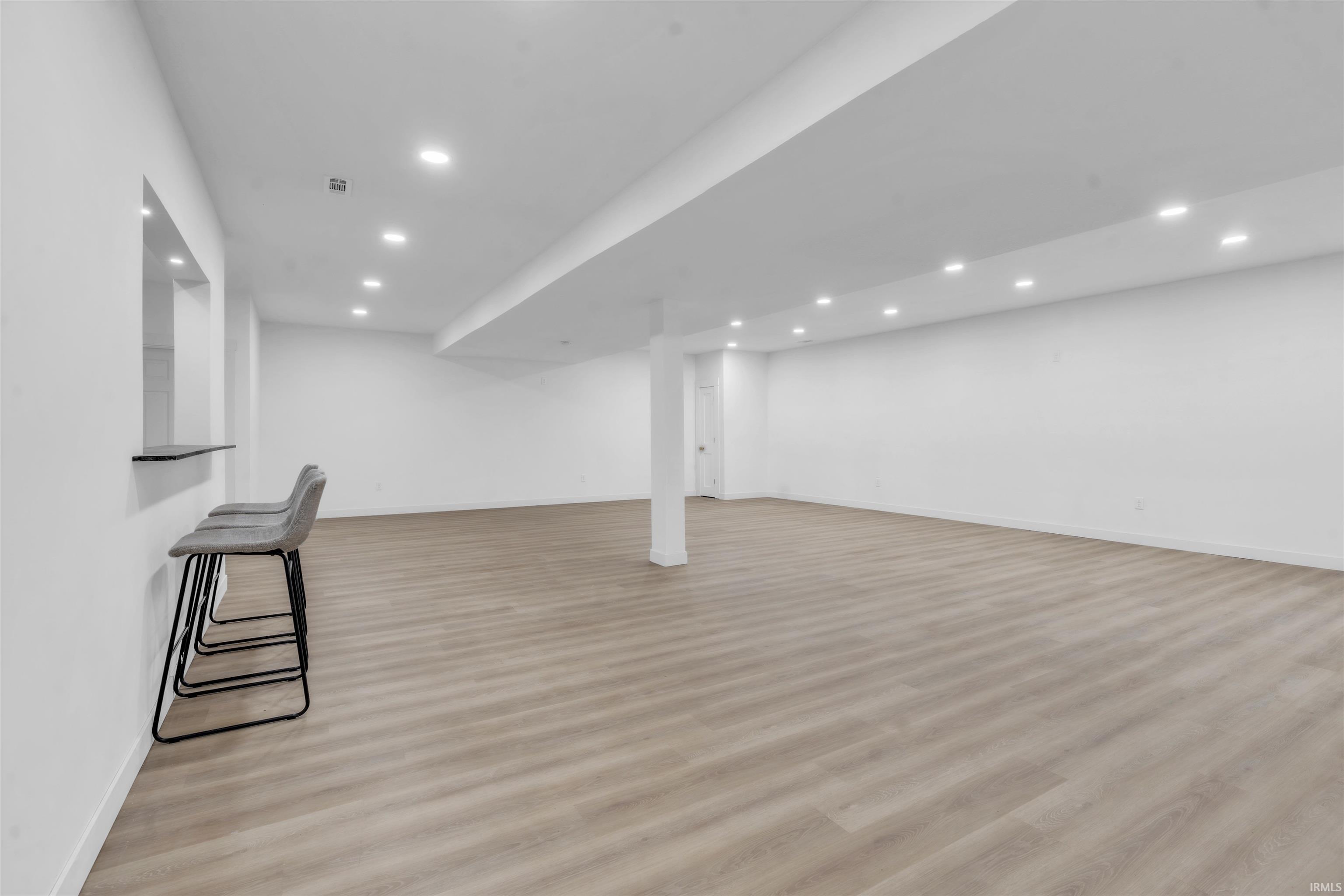 Finished below grade area with light wood finished floors and recessed lighting