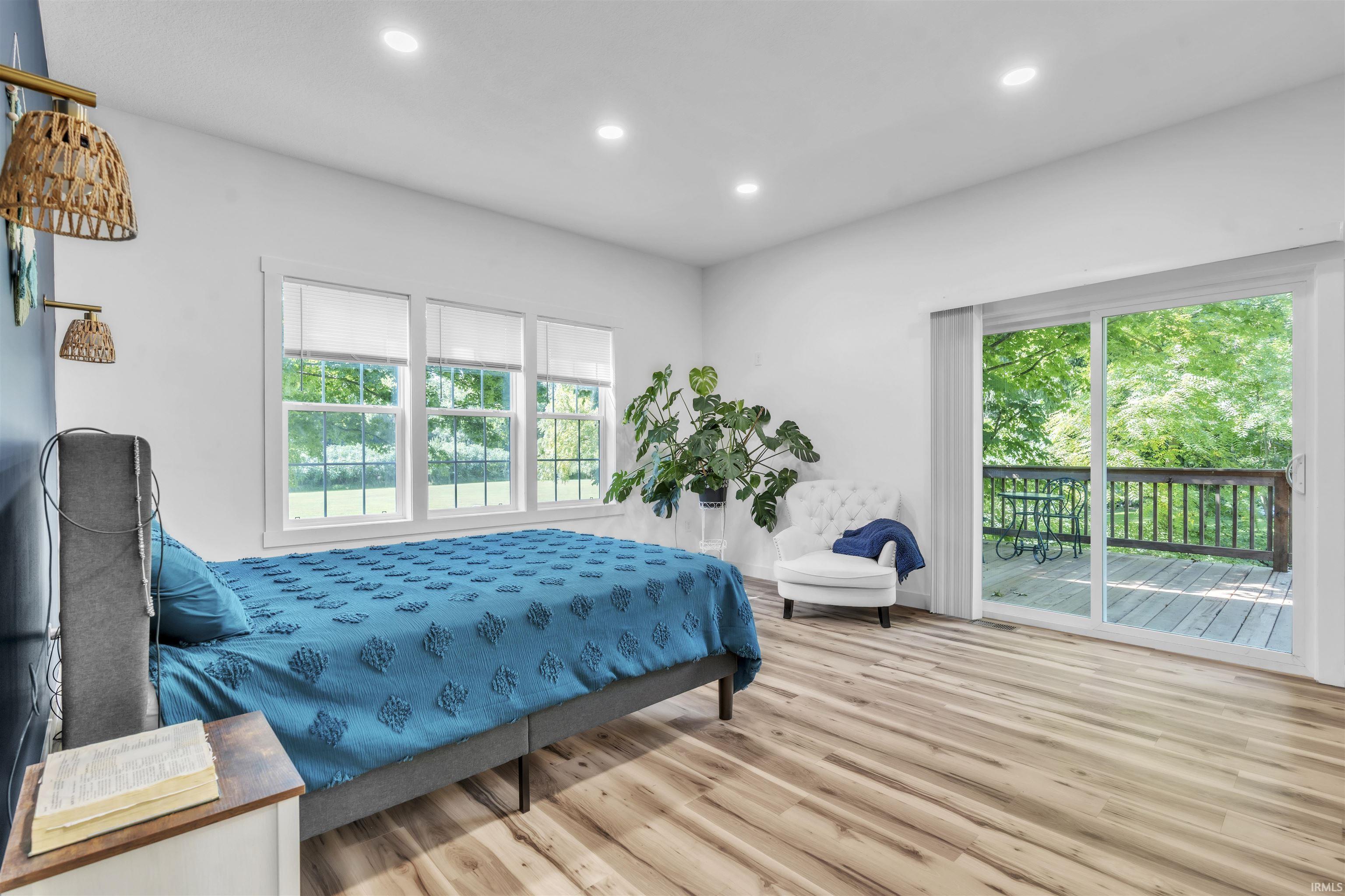 Bedroom with access to outside, light wood-type flooring, and recessed lighting