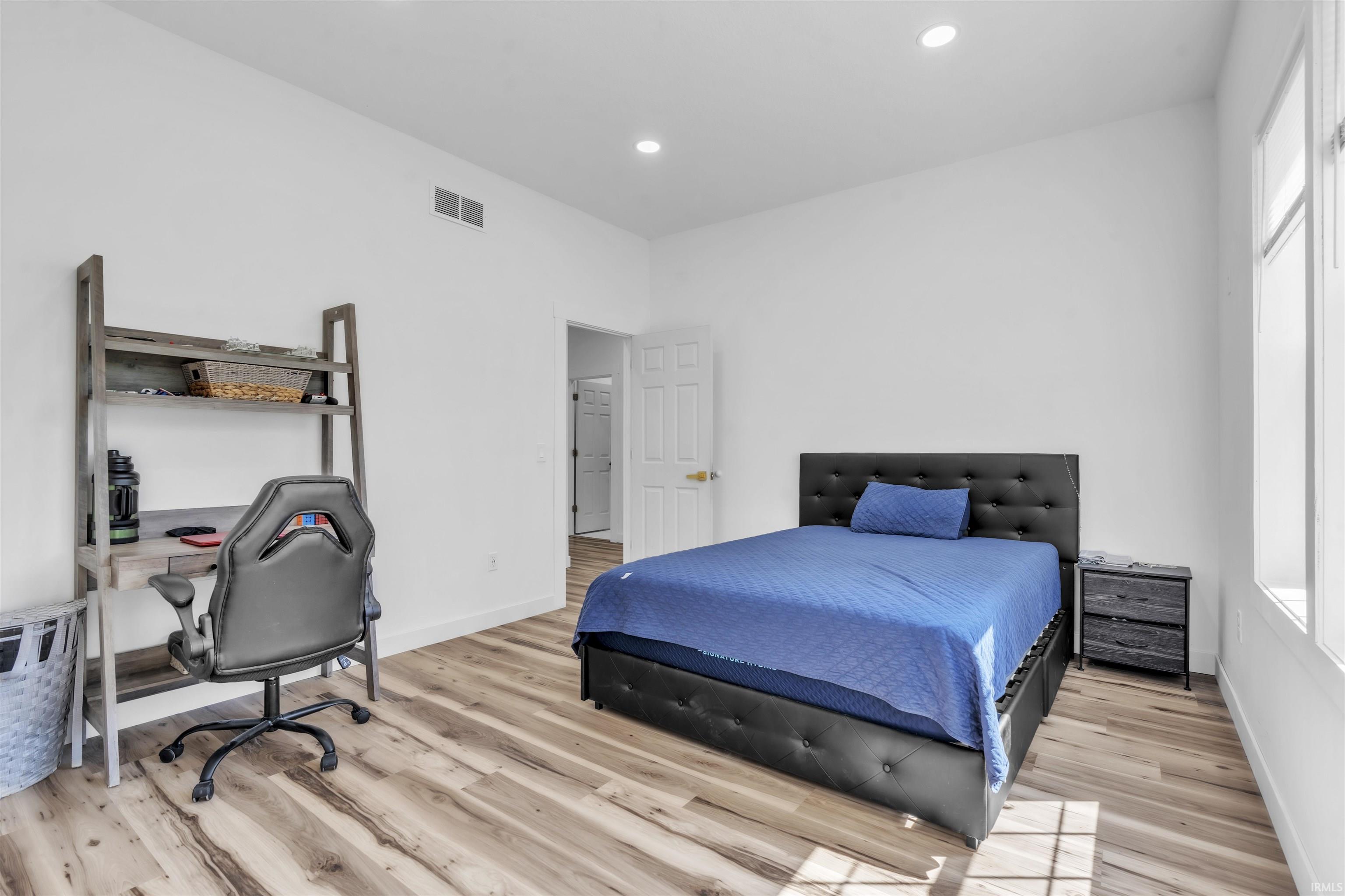 Bedroom featuring a desk, light wood finished floors, and recessed lighting