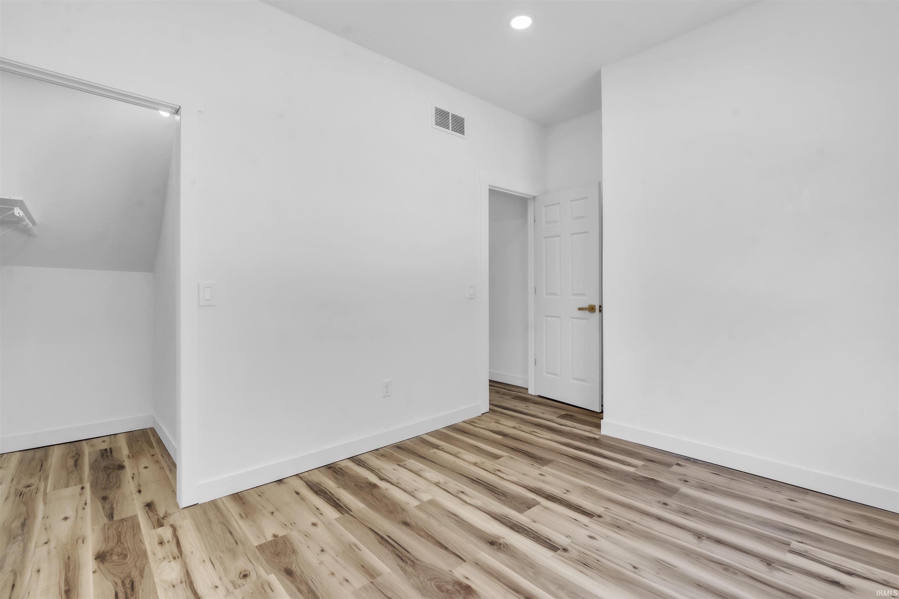 Bonus room with light wood finished floors and recessed lighting
