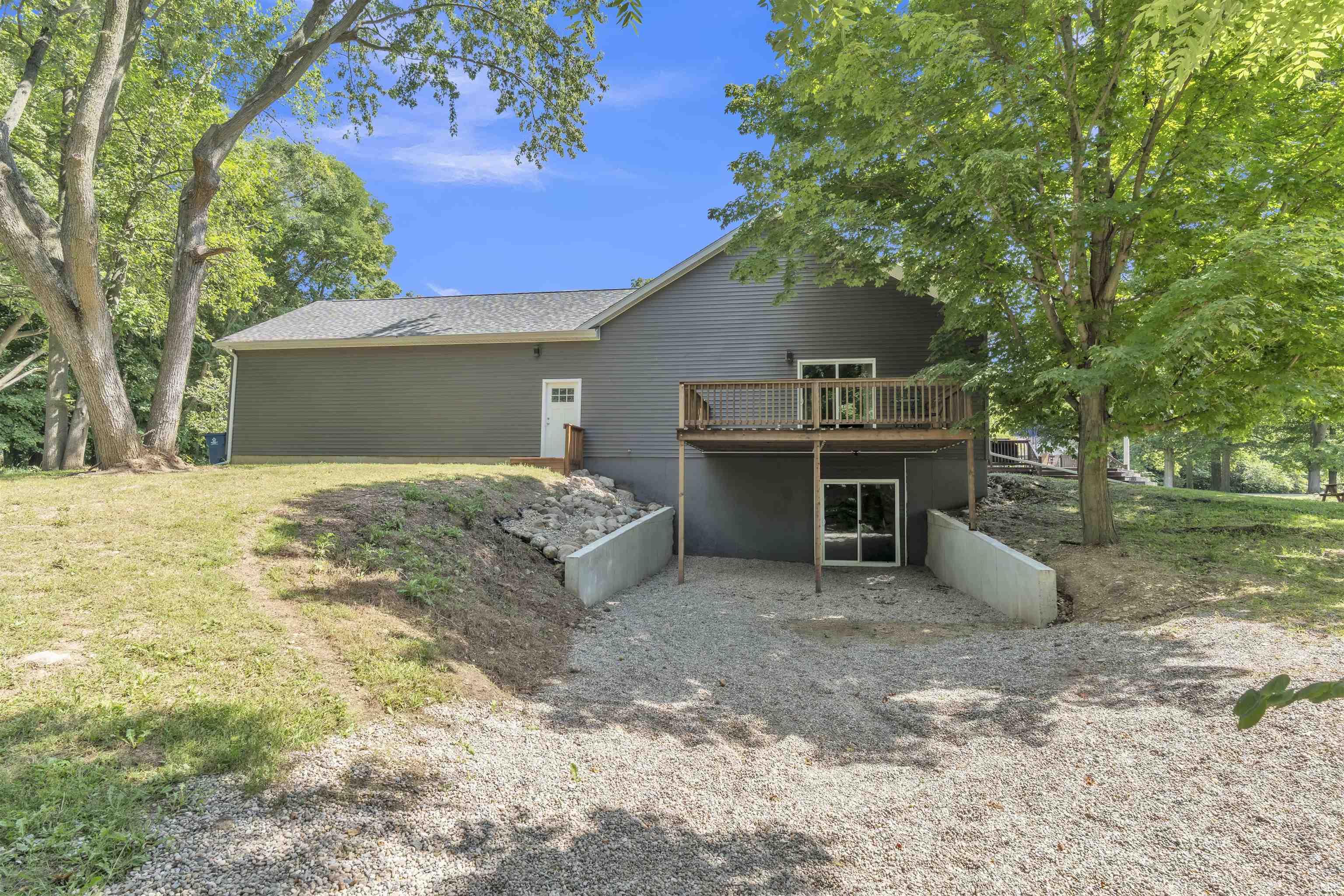 Back of house with a deck and a yard