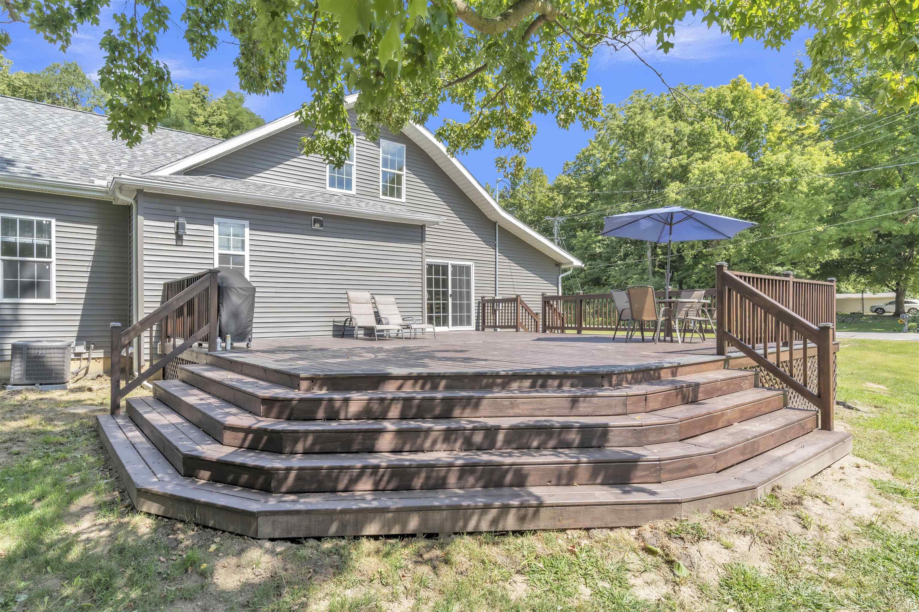Rear view of house with a deck and a shingled roof