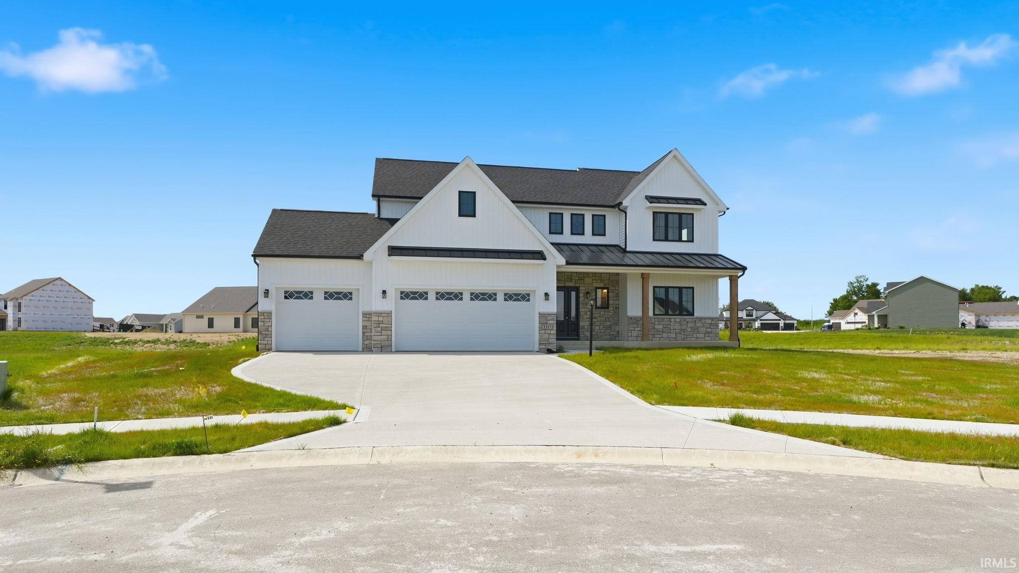 Modern farmhouse style residence featuring white horizontal siding and dark shingle roofing