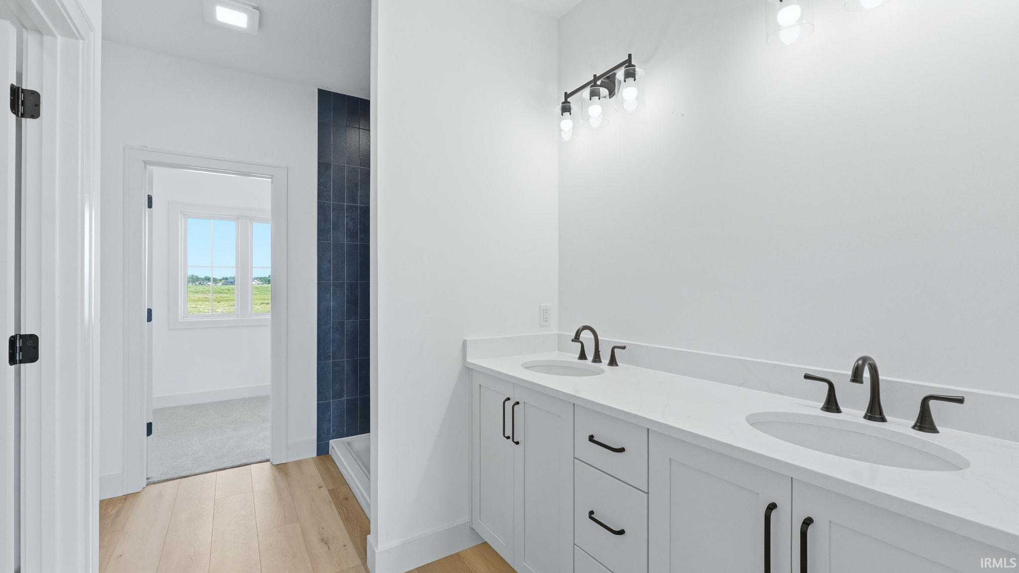 Dual vanity with white cabinetry, white countertops, and matte black fixtures