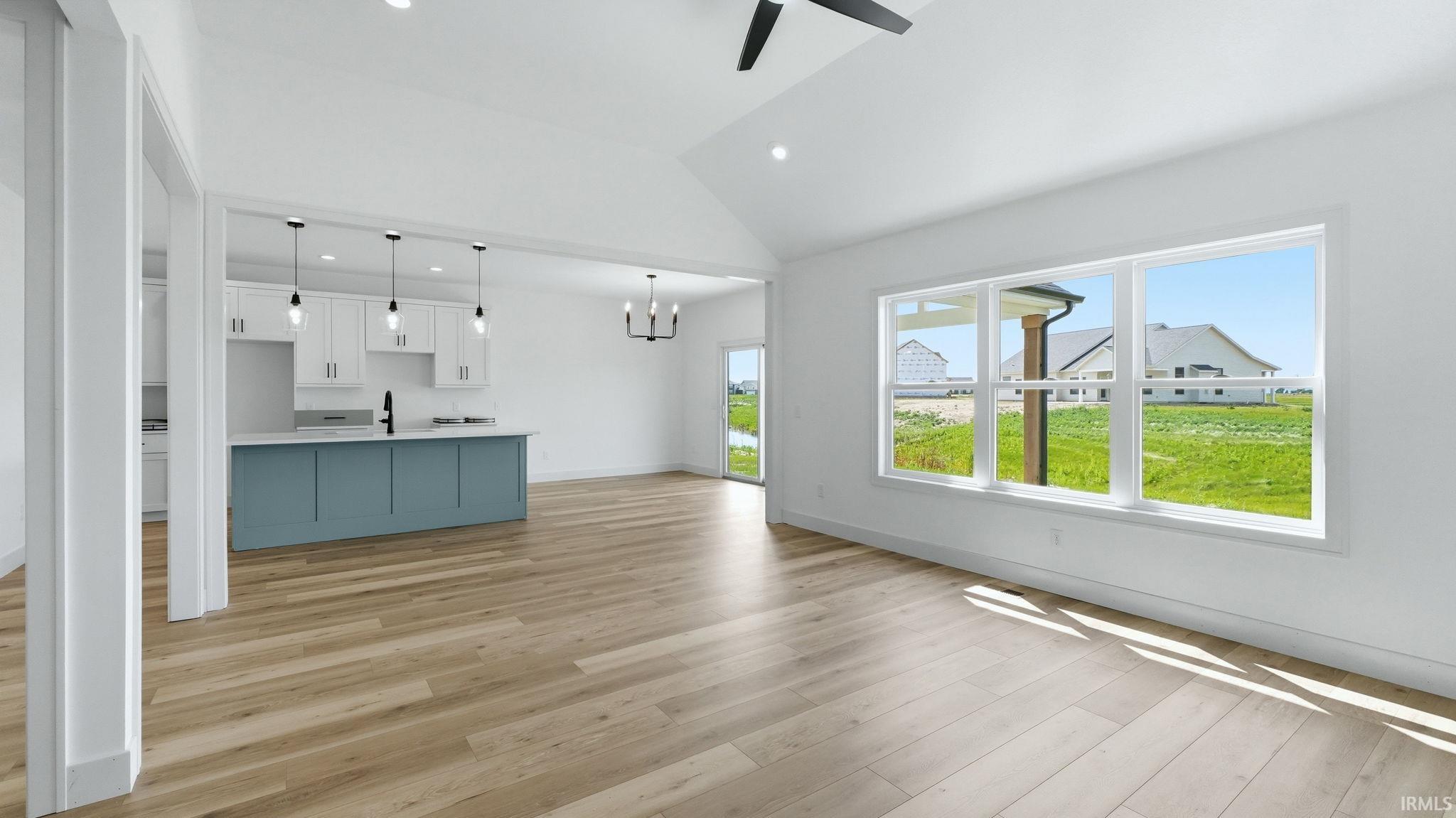 Expansive living area with high vaulted ceilings and wood-finish flooring