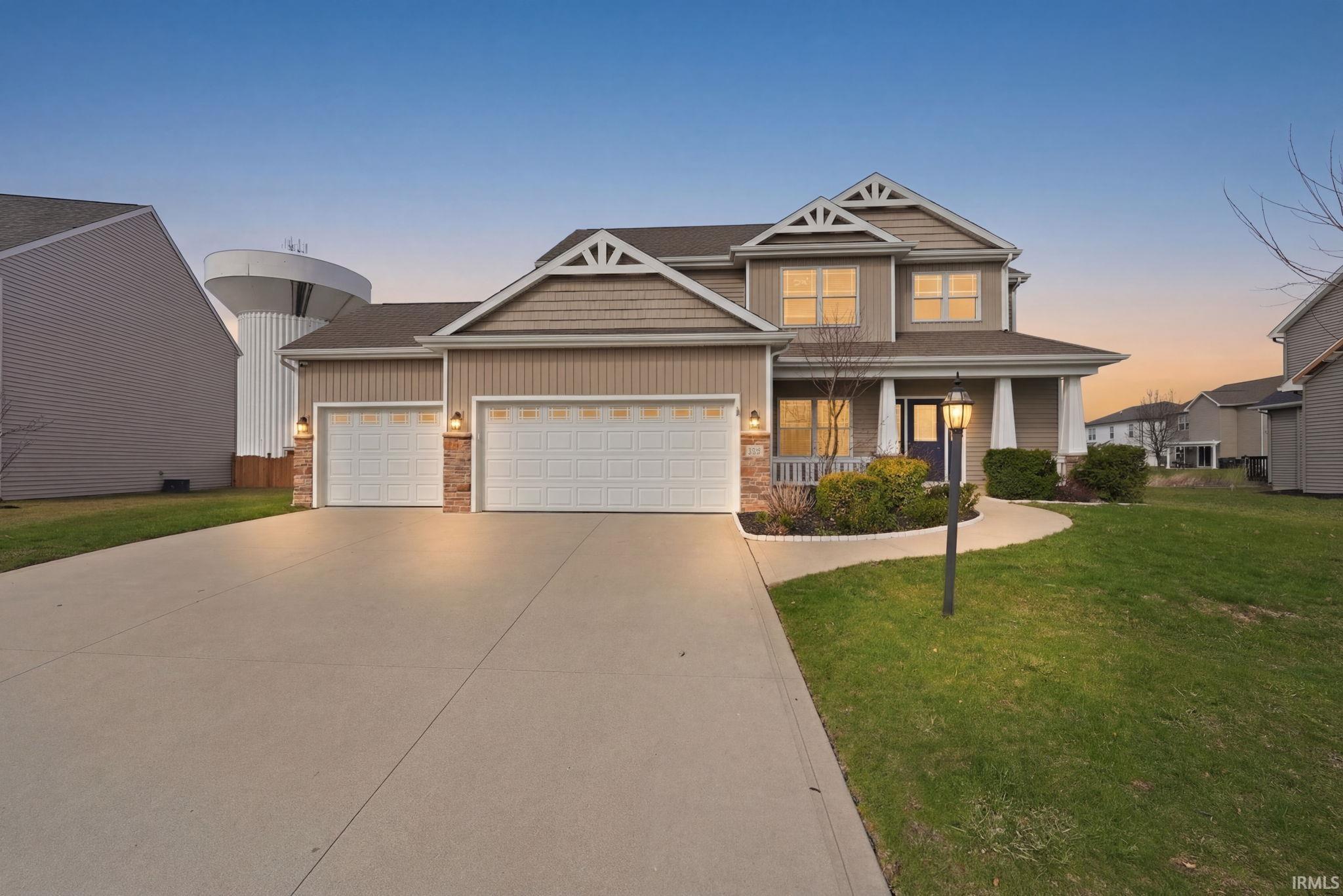Contemporary two-story residence featuring a prominent covered entry porch and a two-car garage