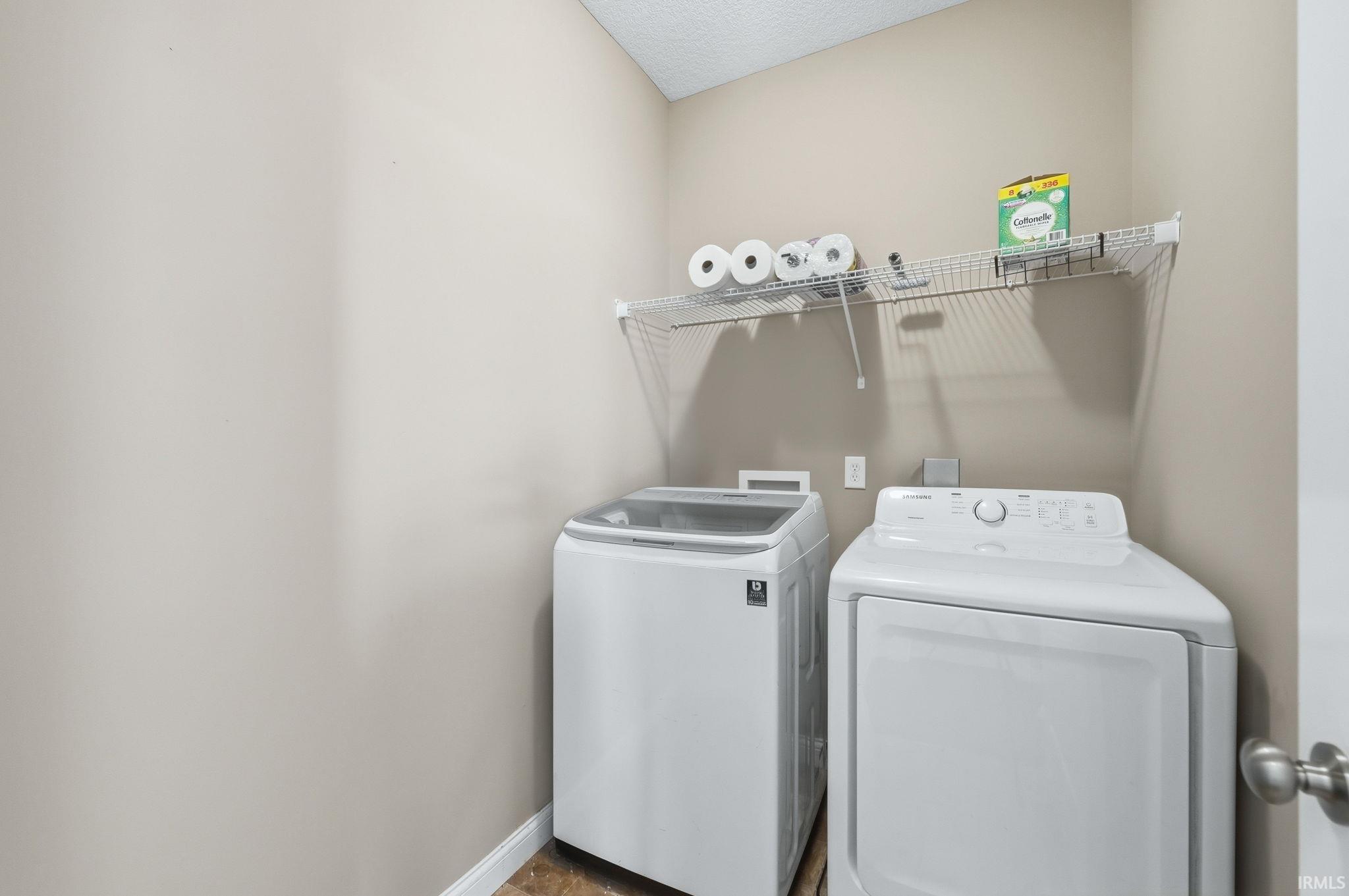 Laundry room featuring baseboards and washing machine and dryer