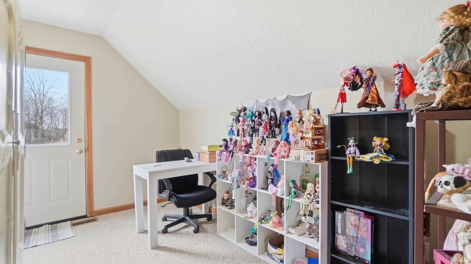 Office area featuring lofted ceiling and light carpet