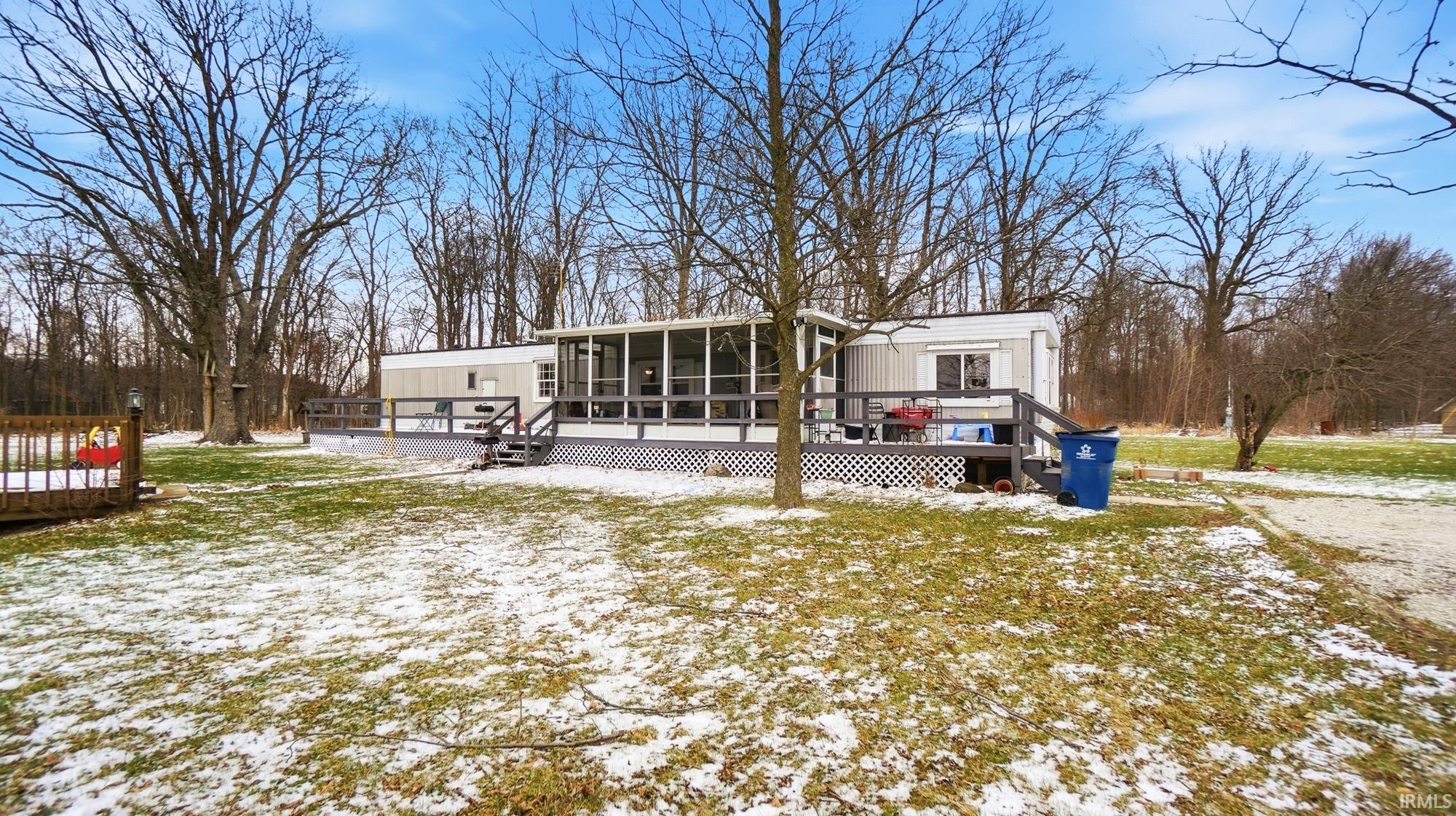 Snow covered house with a wooden deck