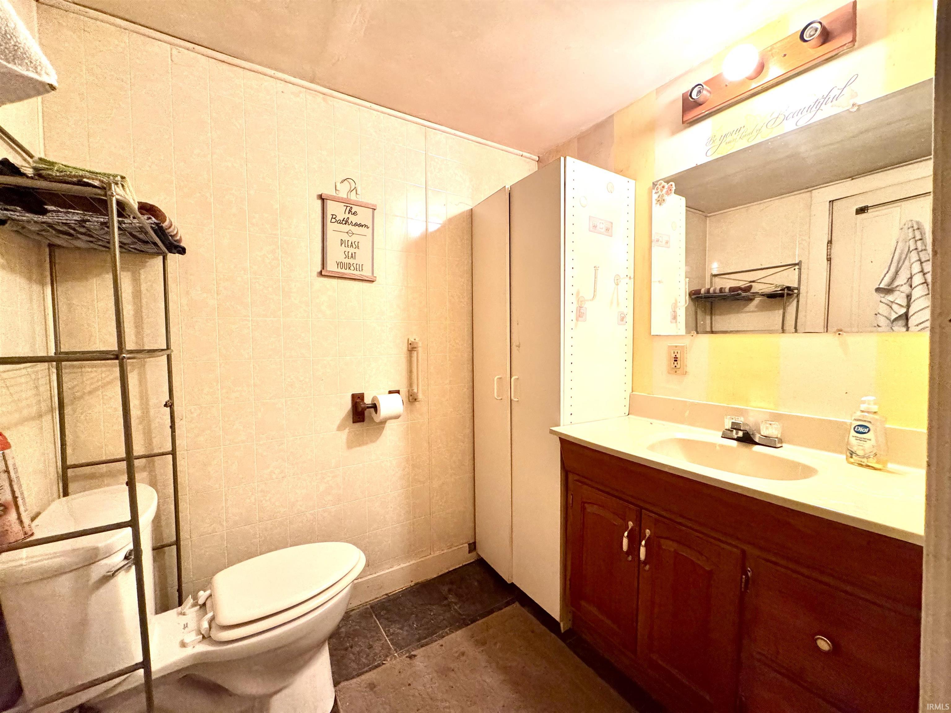 Bathroom featuring vanity and tile walls