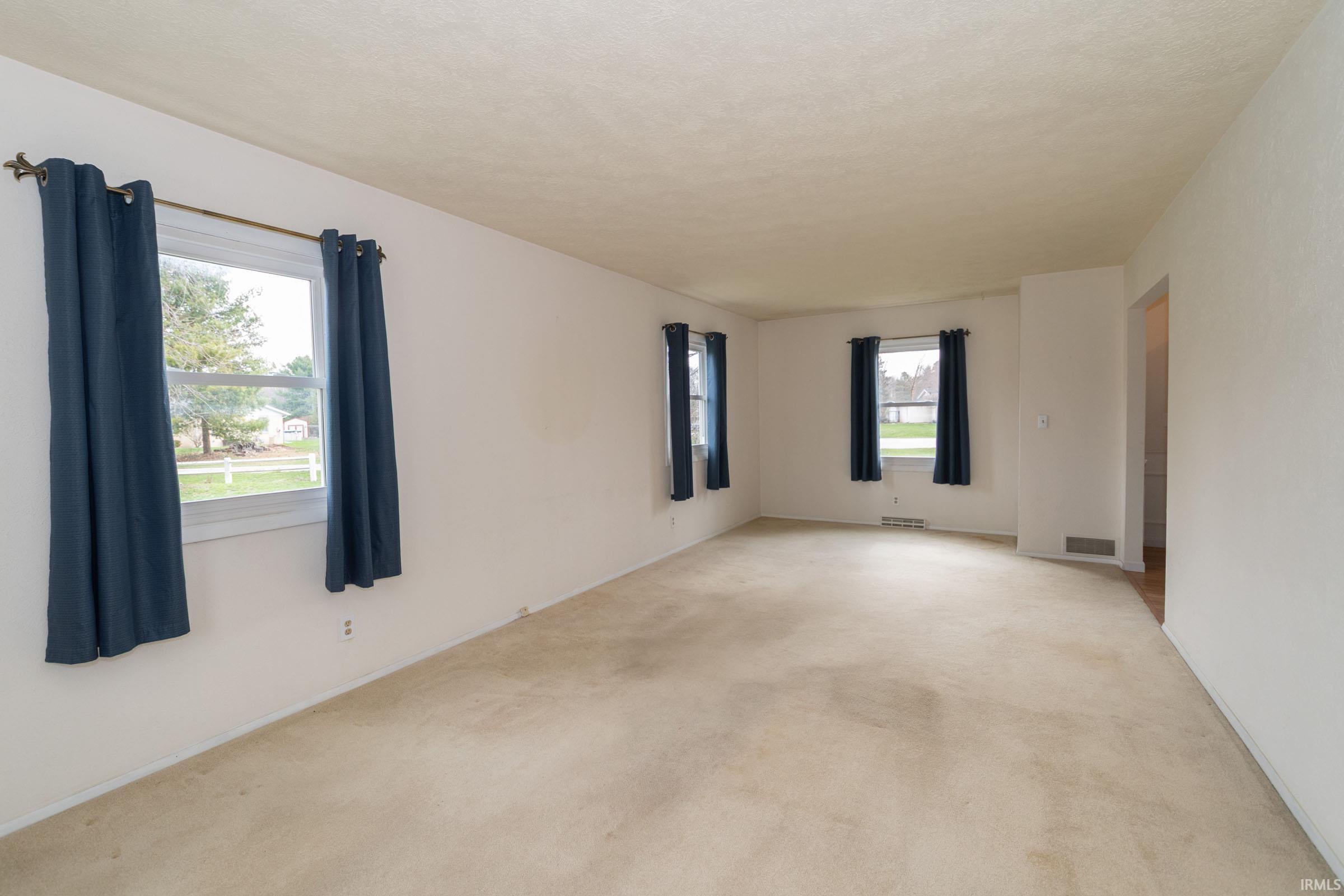 Spare room featuring light carpet and a textured ceiling
