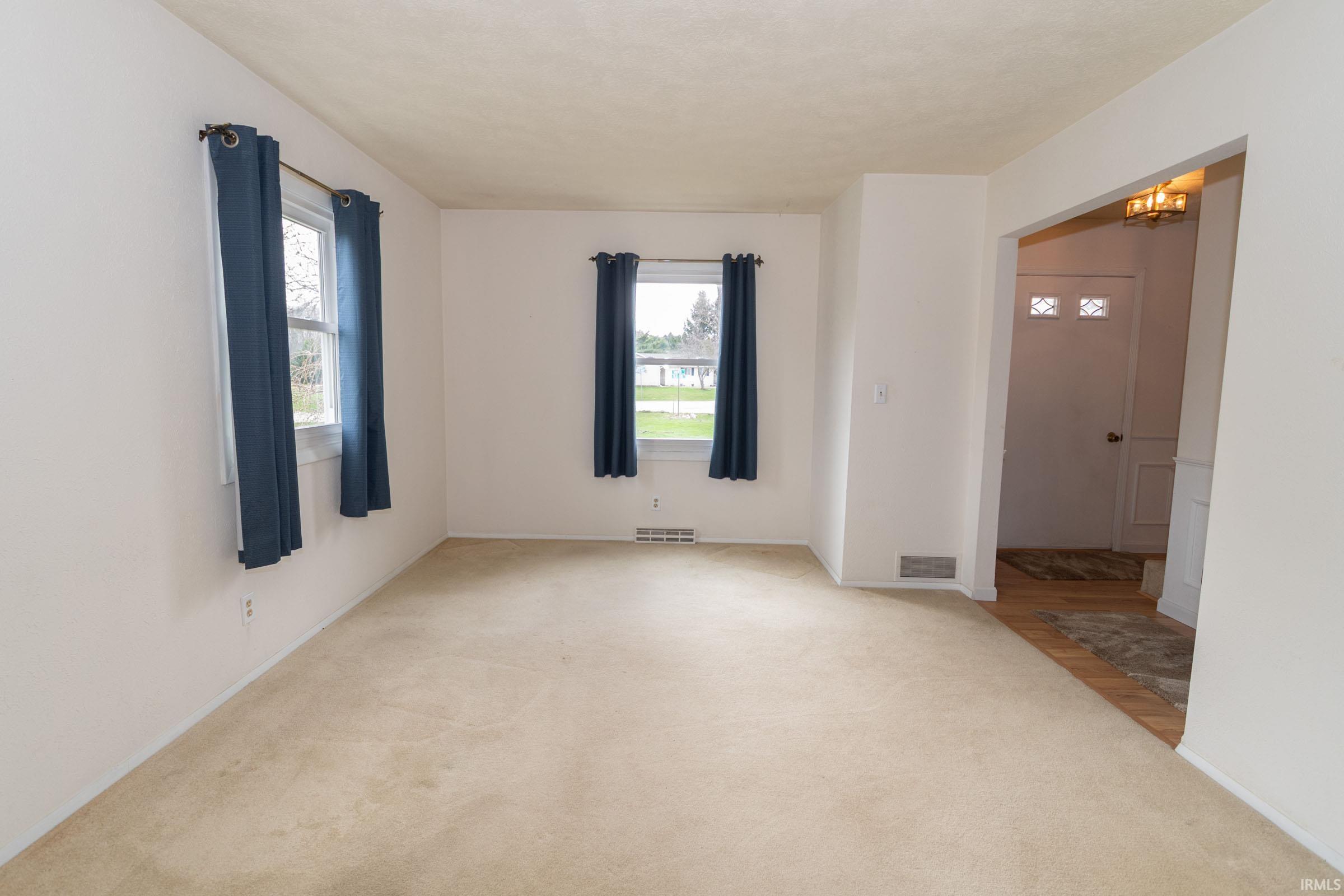 Empty room with light carpet and baseboards