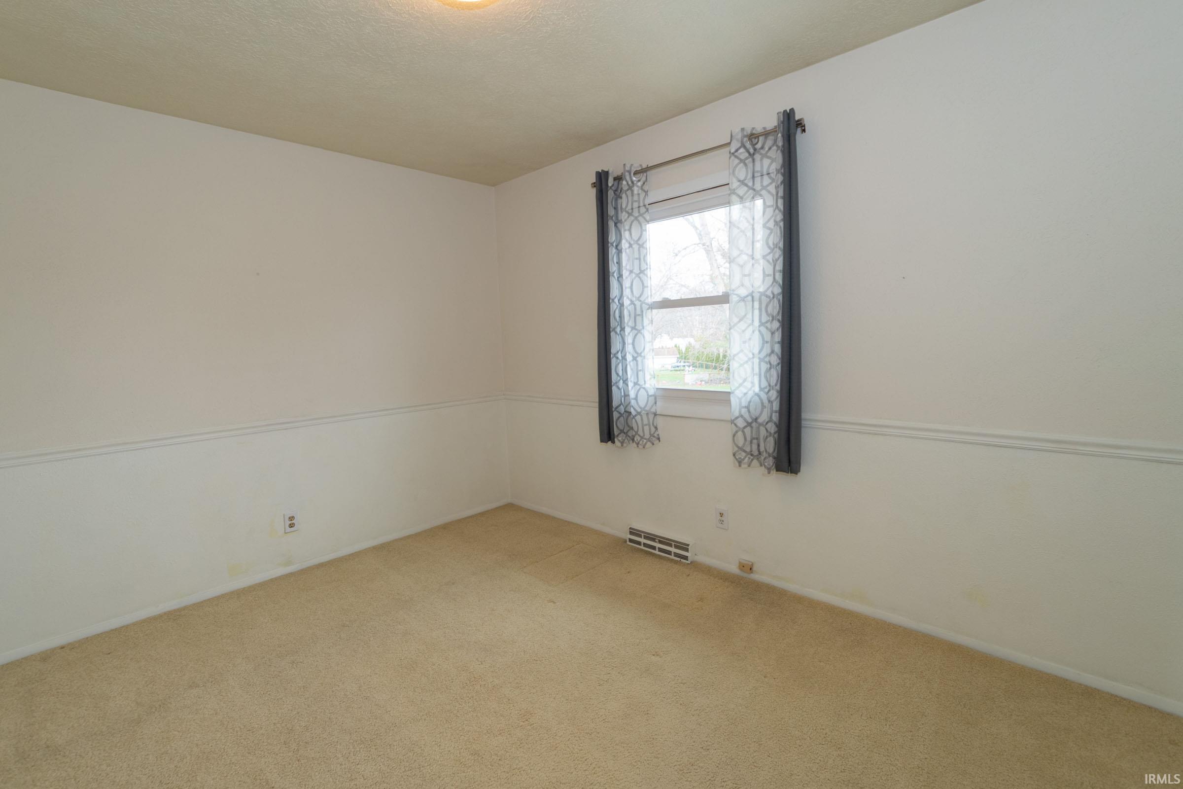 Empty room with carpet floors and baseboards