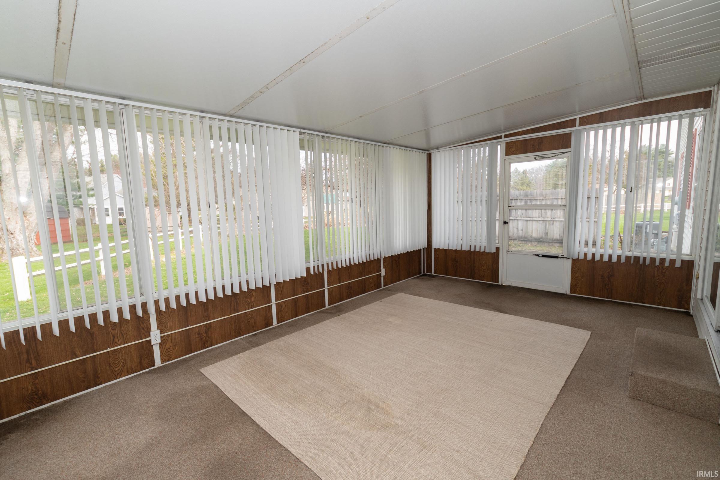Unfurnished sunroom featuring vaulted ceiling